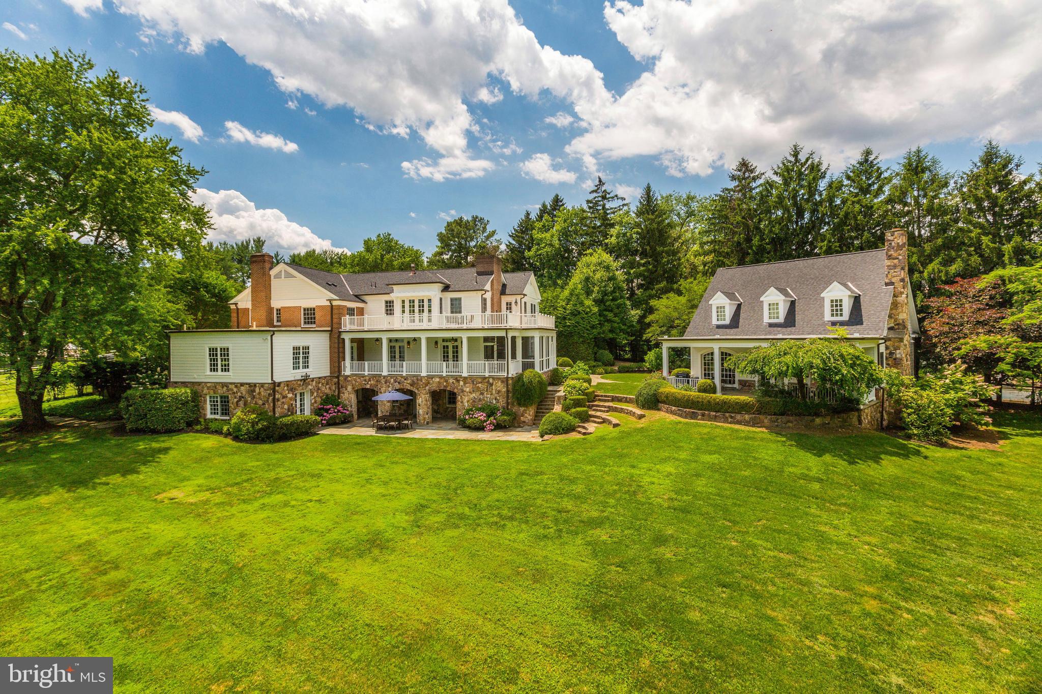 Prepare to be enchanted! Paradise found with this tranquil beauty. A unique opportunity to have over 5 extraordinary acres with mature trees and sweeping lawn on the border of McLean and Great Falls.  As you enter the gates you are greeted by a tree-lined, cobblestone path leading to the Main House that is a quintessential balance of comfort and elegance with custom high-end finishes and a charming Guest House.  Once you are welcomed through the front door you will feel right at home with spacious formal rooms perfect for entertaining, a generous Library with custom built-ins great for sharing or zooming and a cozy sunroom overlooking the gardens. The attention to detail continues with the Family Room that has a gorgeous Stone Fireplace opens to the custom-designed Kitchen with top-of-the-line appliances, oversized Marble Island, Coffee Bar, Pantry with extra Refrigerator and Breakfast area with floor to ceiling windows that opens to the screened-in Porch with Fireplace. There is also a large Mud Room, Family and Formal Powder Rooms on the Main Level. The Upper Level has a fabulous Owner's Suite that includes a luxurious Bedroom with Fireplace, sumptuous Spa Bath with heated floors, walk-in Closets, Breakfast Bar, Office and Balcony with spiral staircase. There are four additional Bedrooms and a fantastic Laundry Room on the Upper Level. The walk-out Lower Level includes a wonderful Recreation Room, Home Theater, Guest Room/Gym with Full Bath, Wine Room and Bar that opens to a covered Terrace and lots of storage inside and out. The Guest House does not disappoint with superior high-end design features that include a beamed vaulted ceiling on the Main Level, 2-story Stone Fireplace, Kitchen, Powder Room, Laundry area. The Second Level includes Bedroom, Loft and Full Bath. There is 3-Car Garage, spectacular gardens and the breathtaking grounds are fully fenced with Gated Entrance! Total square footage includes the Guest House!