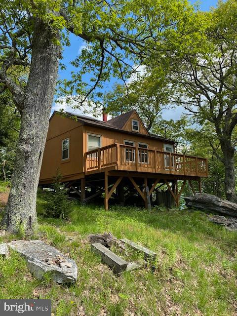 The one room cabin sits on 8.26 acres of land and is recorded as Tract #1.  There is deeded non-exclusive access to a 9.48 acre Common Area for the development that includes Kile Knob property and the hiking trail.  That tract is adjacent to Tract #1.  This makes the property feel much bigger and access to the grand views from Kile Knob are a brief walk. The private driveway winds up the property to the cabin. 

 A tall multi rock formation near the Kile Knob Trail marks the Western boundary.  There are two stakes near the driveway entrance that mark the Southern boundary.  From the Southern boundary, the property stretches out like a baseball diamond.  In the Southern lowlands of the property between the cabin and the driveway entrance is a  flat meadow that deer like to walk through and the owner has set up a modest walking trail down to it. Great area for a firepit and roasting marshmallows. The driveway itself is a hiking asset that completes an enjoyable hiking loop when combined with the Kile Knob hiking trail and deer path that goes by the shed.  The shed houses the electric inverter, has a separate room for batteries, and has plenty of room left over for tools and storage.  The South Facing deck has a propane gas grill and picnic table.  The mature Oaks that anchor three of the four corners of the house provide fantastic shade in the Summer.  The North facing deck has great views of the valley.  Tree-work was performed to enhance the views.
Electric-  The house has a top-of-the-line Magnum inverter located in the shed.  The batteries have not had any issues and have never failed.  The power is supplied strictly via solar panels on the roof of the cabin.  
Heating- The cast iron stove provides great heat on cold nights.  The dampers allow for slow controlled burns to keep wood burning long into the night.  
Water-  Owners always brought their own drinking water to the cabin. Gutters collect rainwater and feed a cistern above the driveway.   A small blue pump in the utility closet provided the pressure to the shower and the sink in the bathroom.  A tankless water heater was connected to the LP tanks and there is a composting toilet.
