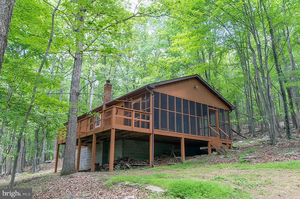 Mountain Cabin Awaits, 2 bedrooms, screen porch and deck, great room with a wood stove for those cool nights. Pine cathedral ceilings, new windows, exterior stain, and screens. All on 6 acres of wooded paradise, enjoy river trips, swimming and fishing throughout the day then relax on your very private screen porch in the evening. Only 2.5 hours from the DC area, this could be the one for you!