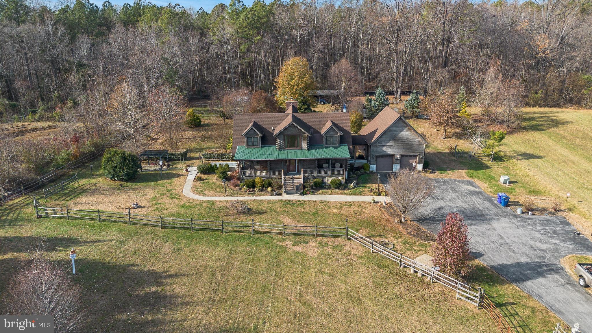 Nestled on over 3 acres of serene landscape, this captivating Cape Cod-style Log Cabin seamlessly blends rustic charm with modern luxury. Boasting 4 bedrooms and 3.5 bathrooms, this property offers a lifestyle of comfort and tranquility. The main-level master suite is a luxurious haven, featuring a private back porch for moments of relaxation. The accompanying bathroom features a jacuzzi tub and separate shower, providing the perfect retreat within your own home. The heart of the home is the kitchen, featuring granite countertops, stainless steel appliances, and a pantry. Whether you're a culinary enthusiast or prefer casual meals, this kitchen is well-equipped to meet your every need. Off the kitchen is an enclosed storage breezeway connected seamlessly to the 2-car garage, offering both convenience and ample storage space. Upstairs features 3 bedrooms, 1 with an amazing picture window and 2 with dual walk-in closets and hardwood floors under the carpet, and a full bathroom. The second-story balcony overlooks the living room with a cozy wood-burning fireplace, providing a stunning view of the cathedral ceiling and contributing to the open and airy atmosphere. The fully finished basement is a versatile space, complete with a full kitchen, full bathroom with multi-jet shower, living room with a gas fireplace, large laundry room, and an optional bedroom. Ideal for guests, a home office, or an entertainment haven, this level offers endless possibilities. Step outside to enjoy the large front porch or the back porch off the kitchen. These outdoor spaces provide the perfect setting to entertain guests, enjoy your morning coffee, or simply revel in the peaceful ambiance of your private oasis. Explore the expansive grounds that include a large front pasture leading to the backyard. Here, you'll find a 3-stall livestock barn, water line, a fenced-in chicken coop, and a dedicated area for your furry friends with a heated/air-conditioned dog house. This property offers more than just a home; it presents a lifestyle. Experience the tranquility of country living with the convenience of modern amenities including new HVAC and propane furnace systems, and a back-up generator.  Located in a sought after school district and conveniently located for easy commuting to the numerous Naval & Joint Military bases in Southern Maryland and Virginia.