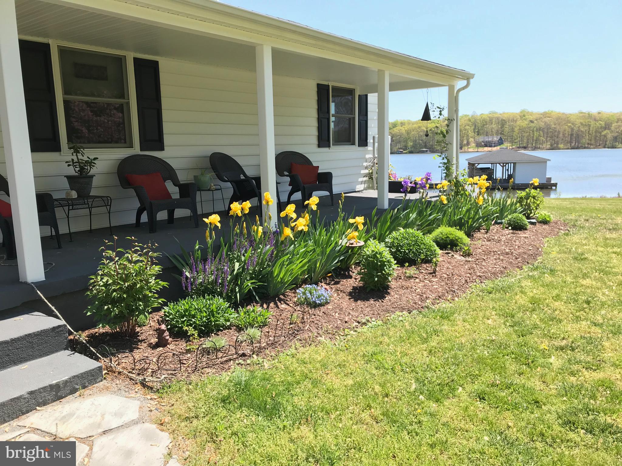 This charming ranch-style home is in a gated, non-HOA, community only 1.5 miles from Food Lion. Enjoy the lake at your own private cove with approximately 300+/- feet of shoreline. There's a 2-slip boat house with a sun deck and storage for all of your lake toys. When you're not by the water, you can still enjoy the lake on your large deck with a hot tub. This home was completely renovated in 2013. The main house has 3 bedrooms and 2 bathrooms on top of an unfinished walk-out basement. Above the single-car attached garage is a one room apartment with a full bathroom. The detached 2-car garage is currently being used as a workshop. Make plans to come see this one!