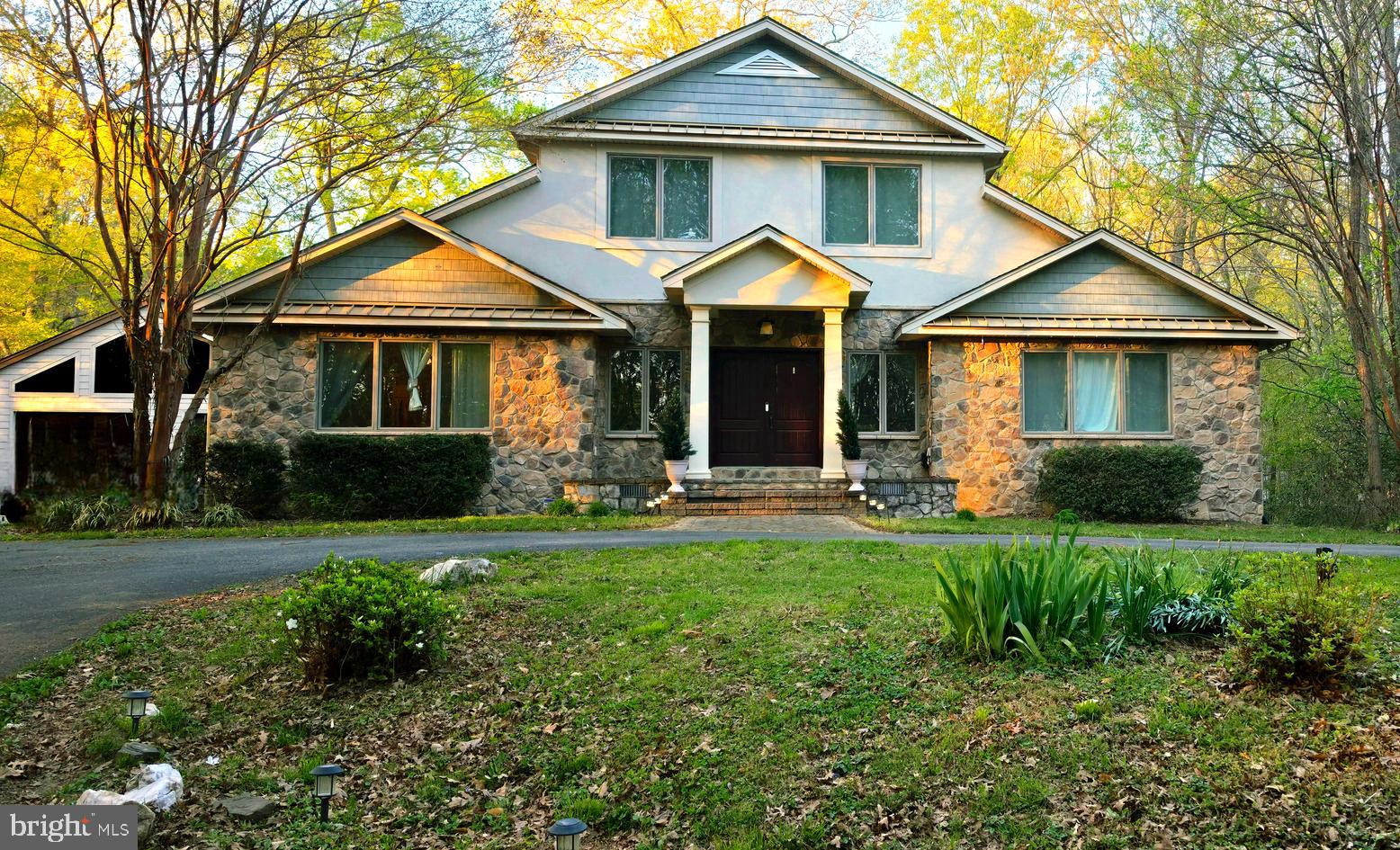 Nestled on a breathtaking 12+ acre picturesque setting just outside the town limits of La Plata, 10060 Harmony Hill offers the perfect blend of luxury, privacy, and convenience — all with NO HOA! A long private driveway welcomes you to this custom estate surrounded by mature trees, peaceful wooded views, abundant wildlife including deer, and a charming front pond that can accommodate koi fish. Approximately 9 acres are currently enrolled in a forestry program offering valuable tax benefits.

The stunning stone front sets the tone for the exceptional craftsmanship found throughout this Contemporary style home. Designed with both everyday comfort and entertaining in mind, this expansive floor plan features multiple living and gathering spaces, including a dining room, all-season sunroom, and spacious living room with a stone electric fireplace, vaulted ceilings, crown moulding, and impressive 10-foot ceilings. Additional features include insulated windows, a whole home Nuvo music system, and a whole home Nutone intercom system.

The gourmet kitchen is a chef’s dream, featuring premium stainless steel appliances including a Wolf gas range, Wolf double ovens, Sub-Zero refrigerator, and wine cooler — perfect for hosting unforgettable gatherings.

The main level features three bedrooms, including two spacious suites offering exceptional flexibility for guest accommodations. The upper-level owner’s suite boasts two oversized walk-in closets, heated bathroom floors, a spa-inspired bath with soaking tub, and a flex space/home office complete with custom built-ins and abundant storage. Two expansive storage areas running the length of the home provide exceptional additional space.

The finished lower level features an open recreation room, wood-burning stove, dryer outlet, rough-in/ejector pump for a future wet bar, an additional bedroom/flex space, full bath, and approximately 1,300 square feet of unfinished space ready to become a home theater, gym, or additional living area.

Additional highlights include a whole house propane generator, oversized laundry room, shed, playground that conveys, and a 32x32 oversized detached garage complete with a movie screen and surround sound — ideal for car enthusiasts, hobbyists, entertaining, RVs, boats, or recreational vehicles.

Enjoy the serenity of this private wooded retreat while remaining just minutes from University of Maryland Charles Regional Medical Center, shopping, dining, schools, local theater, marinas, the Potomac River, and convenient commuter routes to Washington, DC, Virginia, and nearby military bases.

This extraordinary property is truly one-of-a-kind and a must-see!
