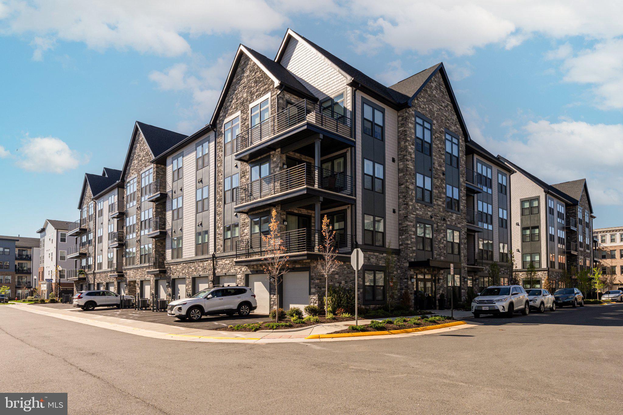 Priced to sell, this smart alternative to new construction, Residence #406 at Archer Square in Birchwood at Brambleton delivers the best of both worlds—thoughtfully upgraded during the build process and gently lived in for just a few months, so you can move right in and start enjoying the lifestyle without delay.

Step inside and immediately feel like you’re home: soaring 10-foot ceilings, wide-plank LVP flooring, and refined trim work create a bright, sophisticated atmosphere. The open-concept kitchen is truly the heart of the condo, featuring upgraded ceiling-height cabinetry, quartz countertops and backsplash, a large island for gathering, and upgraded stainless steel appliances—including a 5-burner gas range and wine refrigerator—ideal for both everyday living and entertaining.

The spacious living area is anchored by a cozy electric fireplace and flows seamlessly to your private balcony—perfect for morning coffee or unwinding with Catoctin mountain views in the background. A versatile den with custom built-ins offers the flexibility for a home office, reading retreat, or guest space.

Your primary suite is a peaceful sanctuary, complete with a custom walk-in closet and a beautifully appointed bathroom featuring a double vanity and rainfall shower. A second full bathroom adds comfort and convenience for guests.

Beyond the home, life at Birchwood is about more than just where you live—it’s how you live. Residents enjoy access to resort-style amenities including a clubhouse, indoor and outdoor pools, fitness center, pickleball and bocce courts, art studio, golf simulator, and an active calendar of social events and clubs. Scenic walking trails, a lakeside park, and thoughtfully designed gathering spaces create a true sense of community.

Condo fees include; building and community amenities, basic cable package, trash, water, snow removal and common grounds/ building maintenance. 

With elevator access, a private 1-car garage, dedicated package room, and secure entry, every detail has been considered for ease and peace of mind. Plus, you’re just minutes from shopping, dining, and entertainment at Brambleton Town Center, with convenient access to major routes and Washington Dulles International Airport.

This is more than a home—it’s a lifestyle upgrade. Welcome to the next chapter.
