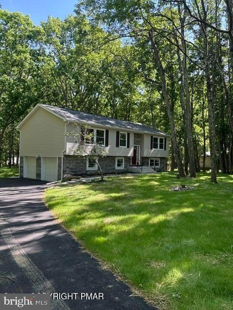 Welcome home to Sierra View in the Beautiful Pocono Mountains. Nestled on a spacious one-acre lot in lower Sierra View, this beautifully updated Bi-level home offers the perfect combination of comfort, convenience, and peace of mind. Offering 2,368 square feet of living space, this move-in-ready home features 3 bedrooms, 1 1/2 baths, and a 2 car garage with automatic door openers. This home offers many updates including new windows, new roof, gutters, siding, mini-split heating and a/c system, garage doors, new rear deck, flooring throughout, stainless steel appliances, lighting fixtures, ceiling fans, drywall, insulation, completely renovated bathrooms, water holding tank, and recently installed front and rear walkways. Low taxes and low dues in the Pleasant Valley School district. Conveniently located minutes from Pocono Raceway, ski resorts, casinos, shopping, restaurants, schools, and major routes. This home is ready to move in to today! Sellers wife is a PA Licensed Realtor.