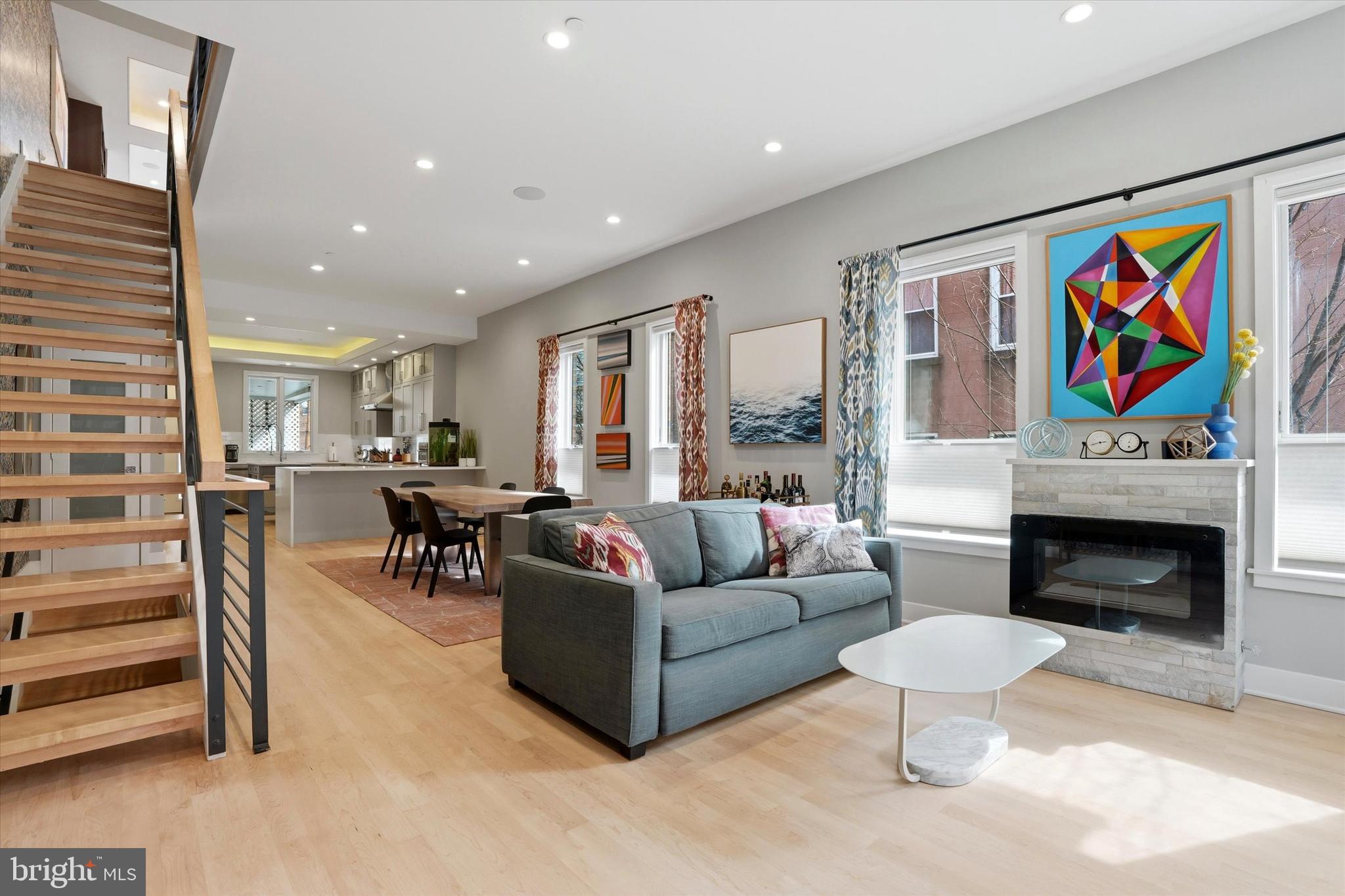 Welcome to 741 S. 15th Street—a striking corner residence where thoughtful design, custom craftsmanship, and abundant natural light from the east, south, and west create a truly exceptional home. From the moment you enter, this property stands apart, with curated wallpaper accents and smart, creative storage solutions that balance style and function throughout. The main level is bright and inviting, featuring oversized windows on multiple exposures, soaring ceilings, and newly refinished light hardwood floors. The open-concept living and dining area is flooded with natural light, while the chef’s kitchen serves as a true centerpiece—complete with ceiling-height Shaker cabinetry, a waterfall peninsula with seating, and a full suite of high-end appliances including a Wolf cooktop with chimney hood, double wall ovens, pot filler, Bosch dishwasher, and wine fridge. Additional highlights include a farmhouse sink, generous pantry storage, and unique “countertop windows.” Just beyond, enjoy the rare convenience of covered two-car parking, creating a private outdoor retreat above that seamlessly extends the second-floor living space. Upstairs, the home continues to impress with a dramatic family room featuring custom built-ins, a gas fireplace, tray ceilings, and a sun-drenched wall of south-facing windows, along with access to an east-facing deck. A dedicated laundry area adds everyday convenience. Both the second- and third-floor front bedrooms offer dual exposures, generous proportions, built-in storage, and full baths with modern finishes. The primary suite is a true retreat, filled with natural light and complete with a custom walk-in closet, additional built-ins, and a spa-like bath featuring a soaking tub, double vanity, and oversized shower. At the top, the roof deck is exceptional—complete with a wet bar, wine refrigerator, and powder room in the pilot house, along with sweeping skyline views ideal for entertaining or relaxing above the city. The lower level offers a fully self-contained one-bedroom, one-bath suite with a private entrance, living area, and full kitchen—ideal for guests, extended living, or potential rental income. Additional features include dual-zone HVAC, a sprinkler system, and one year remaining on the tax abatement for added peace of mind. Ideally located in Graduate Hospital, just steps from neighborhood favorites like The Lodge by Two Robbers, Rex at the Royal, Suprema Coffee Roastery, and the YMCA.