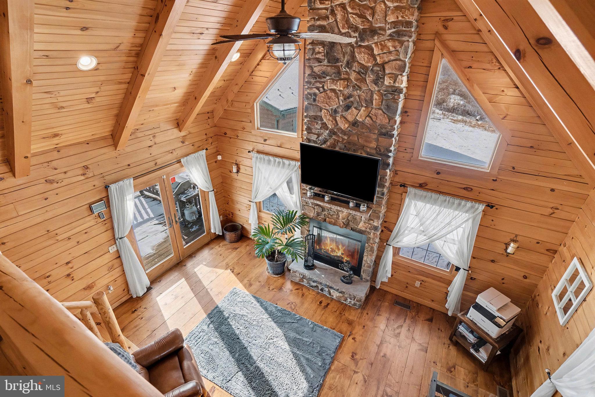 A Stunning log home minutes away from from Penn State. This extraordinary 60+ acre property truly has everything. Whether you’re a Penn State fan looking for a private game-day retreat or seeking a serene weekend escape to share with family and friends, this one-of-a-kind estate delivers privacy, versatility, and unforgettable views—just minutes from the stadium.

As you wind up the driveway, the peaceful beauty of the land immediately sets the tone. A stunning three-level log home comes into view, complemented by a massive heated and cooled garage with oversized bays capable of housing an RV, plus a private apartment ideal for guests, in-law quarters, or game-day VRBO opportunities.

Inside the Home:
The lower level features a spacious entertainment room complete with a bar and wood burning stove—perfect for watching the big game—along with a guest bedroom. The main level showcases a large great room with two decks, offering ideal spaces for entertaining or just enjoying a peaceful day as the sun fills the space featuring a wood burning stone fireplace. The adjacent kitchen provides ample room for gatherings and flows seamlessly to the front porch, where rocking chairs frame a picturesque, peaceful view.

The upper level is dedicated to a private primary suite featuring an attached bathroom—your personal retreat from the world.

Off of the great room, step outside to the expansive back deck, ideal for family gatherings or quiet evenings surrounded by nature.

Garage & Apartment:
The heated and air conditioned garage is a car enthusiast’s dream, equipped with a heavy steel beam suitable for engine pulls or processing game, and already marked for a future car lift. On the opposite side, a private one-bedroom apartment offers excellent accommodations for guests, in-laws, or short-term rental potential. The apartment also features an impressive built-in gun safe, perfect for the outdoor enthusiast.

Outdoor Features:
Additional amenities include a shed and a “she-shed,” a fully equipped chicken coop designed for both egg-laying and meat chickens, solar-powered free-range access, and even a chicken isolation private coop. A pond near the coop offers potential for fishing or swimming with a little enhancement.

The land rises up the hillside and provides outstanding hunting grounds, complete with trails throughout and a hunting shack. At the top of the property, you’ll find direct access to Rothrock State Forest, making this an outdoorsman’s dream.

This remarkable property offers unmatched versatility, privacy, and recreation—come experience everything this breathtaking oasis has to offer.

Virtual Staging Disclosure- some photos may have used a software to create a photo or conceptual rendering of what a room or property could look like, if it was staged or lived in.