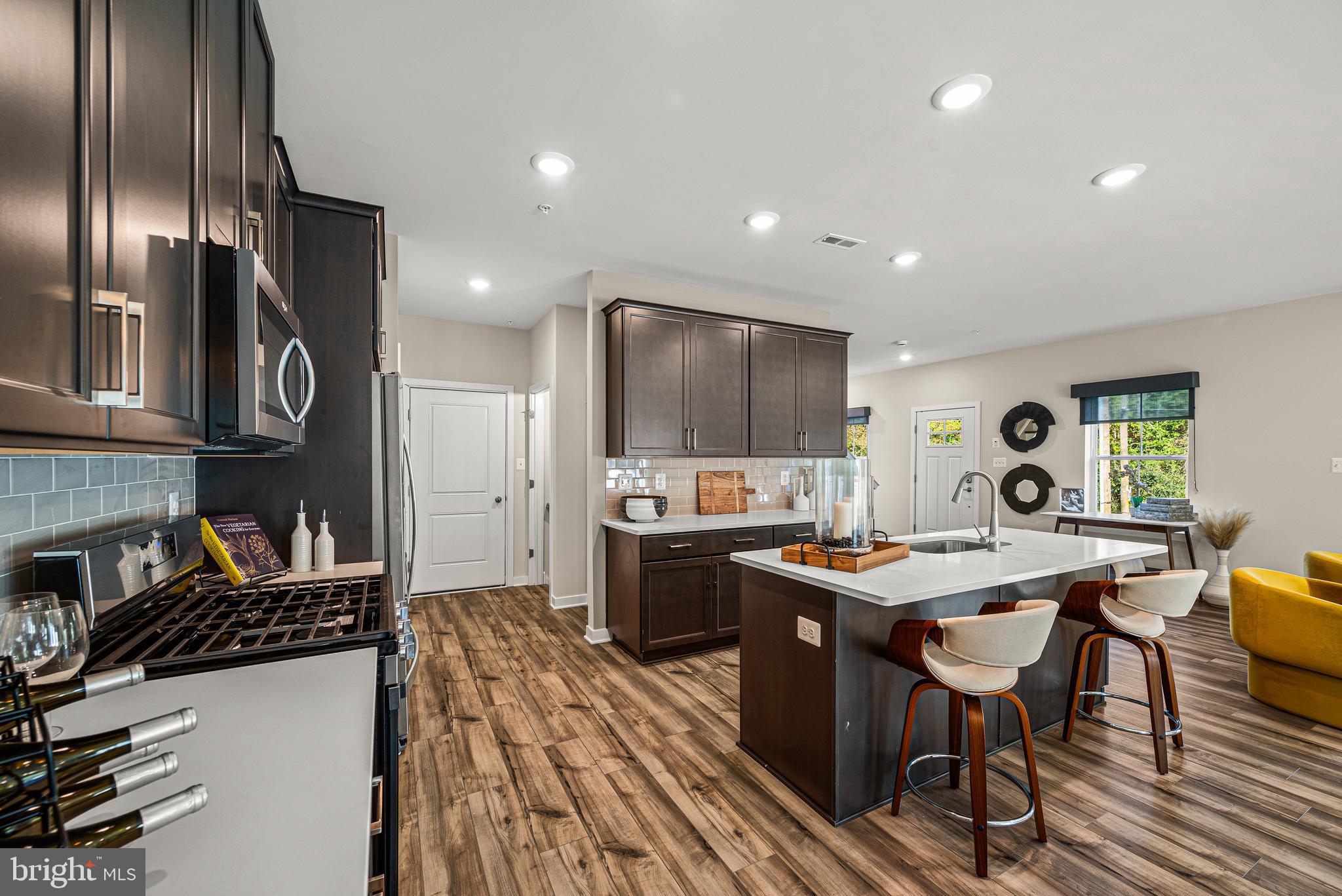 Built as Clover Mill's decorated model and never lived in, this end-of-row townhome carries the kind of details most homeowners spend years adding: custom architectural trim, designer wallpaper accents, statement lighting, and custom window treatments already in place. The kitchen anchors the main level with quartz counters and an oversized island, opening to a living area with wide plank flooring that flows to a low-maintenance deck. The primary suite offers a quiet upstairs retreat, and the finished lower level with powder room flexes as a gym, lounge, or second living space. Generous closets and storage throughout. Two-car garage plus driveway parking. The HOA covers walking trails, common areas, snow removal, trash, and recycling. Within the Downingtown East School District and STEM Academy boundary. The home's professionally selected furnishings are available separately—a true move-in-tomorrow option, without the shopping.