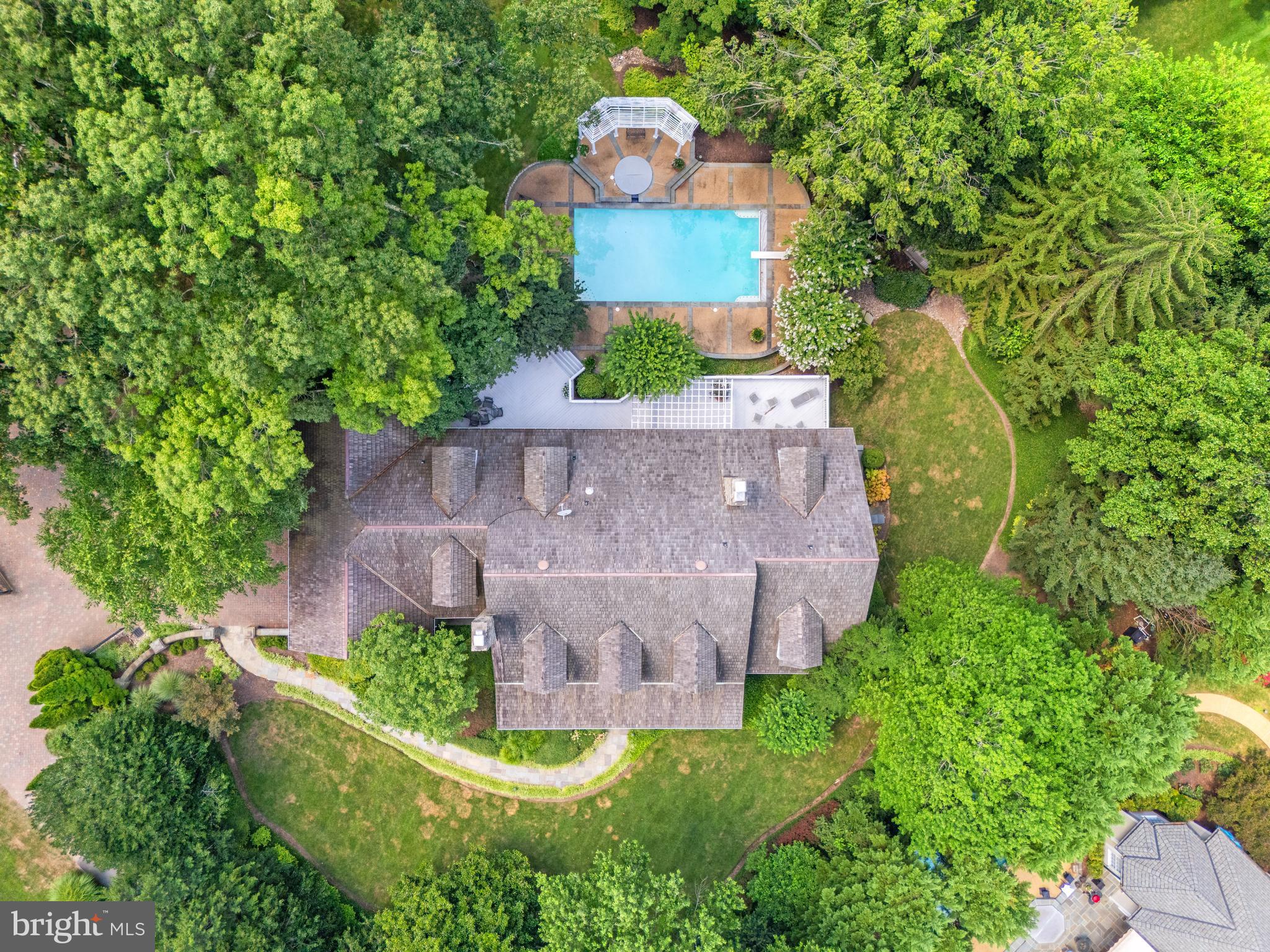 Offering amazing scale with soaring 10-foot ceilings on the main level, 9-foot ceilings upstairs, and an expansive lower level, 1110 Harvey Road impresses with grand rooms and remarkable proportions throughout. Discover an extraordinary estate at 1110 Harvey Road, nestled within the prestigious Langley Farms neighborhood of McLean, VA. This remarkable residence is situated on a private, flat, gated lot that seamlessly blends luxury, privacy, and timeless elegance. Built in 1991, the home showcases high-quality finishes and meticulous attention to detail throughout.
Upon entering the grand two-story foyer adorned with honed marble flooring, you are welcomed into embassy-sized rooms that flow effortlessly from one to another. To the right of the foyer, a spacious library with custom built-ins provides a refined space. To the left, the elegant living room features a custom limestone mantel framing the gas fireplace, adding a touch of classic sophistication. The residence also offers a gracious dining room, perfect for hosting formal dinners and celebrations, with convenient patio access that brings the outdoors in. The impressive two-story family room, anchored by a gas fireplace with a marble surround, creates an inviting space for gatherings of all sizes.
A beautifully appointed butler’s pantry enhances the entertaining experience, featuring custom cabinetry, pantry closet space, Fisher & Paykel dishwasher drawers, a wine fridge, and a beverage fridge.
The kitchen itself is of exceptional quality, boasting Viking double ovens, a Viking range cooktop, a Sub-Zero refrigerator, a prep sink, a Miele dishwasher, a stainless-steel farmhouse sink, and timeless Mexican tile flooring. Venetian plaster walls add an artistic touch to this culinary haven, complemented by a built-in banquette and a planning desk for added convenience.
The main floor is thoughtfully designed with a sought-after primary suite that offers custom built-ins, abundant closet space, and access to a serene outdoor terrace. The spa-like bath provides a private retreat with luxurious amenities dedicated to relaxation and rejuvenation.
The residence includes six spacious bedrooms and six and a half baths, ensuring ample accommodation for family and guests. Upstairs, four generously sized bedrooms are paired with two full baths, each designed with comfort and style in mind.
The lower level is a haven for entertainment and leisure, featuring a fully equipped bar, a billiards room, a recreation room with a projector and pull-down screen, a gym, an office/bedroom with adjoining full bath, and a playroom or nanny room with ensuite full bath. A wood-burning fireplace in the lower-level recreation room adds warmth and ambiance, seamlessly extending the living space while maintaining a sense of coziness and privacy.
Outdoors, the property continues to impress with beautifully landscaped, park-like grounds surrounding a sparkling pool. A full bath on the main floor off the laundry room conveniently serves the pool area. The spacious three-car garage with built-ins, complete with an epoxy floor, ensures both functionality and style. The whole-house generator provides peace of mind, while abundant storage solutions are thoughtfully integrated throughout.
The estate’s exterior is elegantly understated, belying the grand scale and luxurious living spaces within. The deed for 1110 Harvey Road also includes 1114 Harvey Road, combining to offer a sprawling 1.32-acre sanctuary. Situated in a prime location, this exceptional property presents a rare opportunity to own an exquisite residence that embodies sophistication, comfort, and privacy.