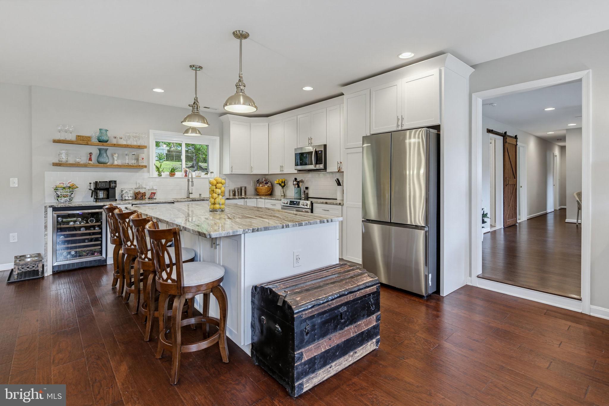 Welcome home to this beautifully rebuilt rancher offering the perfect blend of established neighborhood charm and modern construction. When you enter the home you are welcomed by a spacious Great Room which includes the kitchen that features a huge island with cabinetry on both sides, stainless steel appliances, a large stainless steel sink with a window that looks out to the flat backyard, and a beverage refrigerator that finishes off the kitchen area with beautiful waterfall granite counter.  The sitting area of the Great Room has three large windows that allow tons of natural light.  The dining area of the Great Room features plenty of space for sit down dinners and an entry onto the patio.  The generously sized  family room gives you another comfortable living space that works perfectly for entertaining.  The primary bedroom has dual closets and ensuite primary bathroom, which has a glass enclosed shower with built-in seat, dual sinks, and a large linen closet.  The three remaining bedrooms are nicely sized and have plenty of closet space.  This home also features a convenient laundry room that has cabinetry over the front load washer and dryer.  The natural gas heating system and tankless water heater help keep your utility costs low.  The fully fenced backyard offers plenty of room for entertaining, pets, play, gardening, or simply enjoying the outdoors in privacy.  The roomy shed provides plenty of storage space for all of your yard tools and equipment.
This home is truly the best of both worlds—a thoughtfully rebuilt home with the features and feel of a five-year-old property, nestled in a well-established neighborhood.