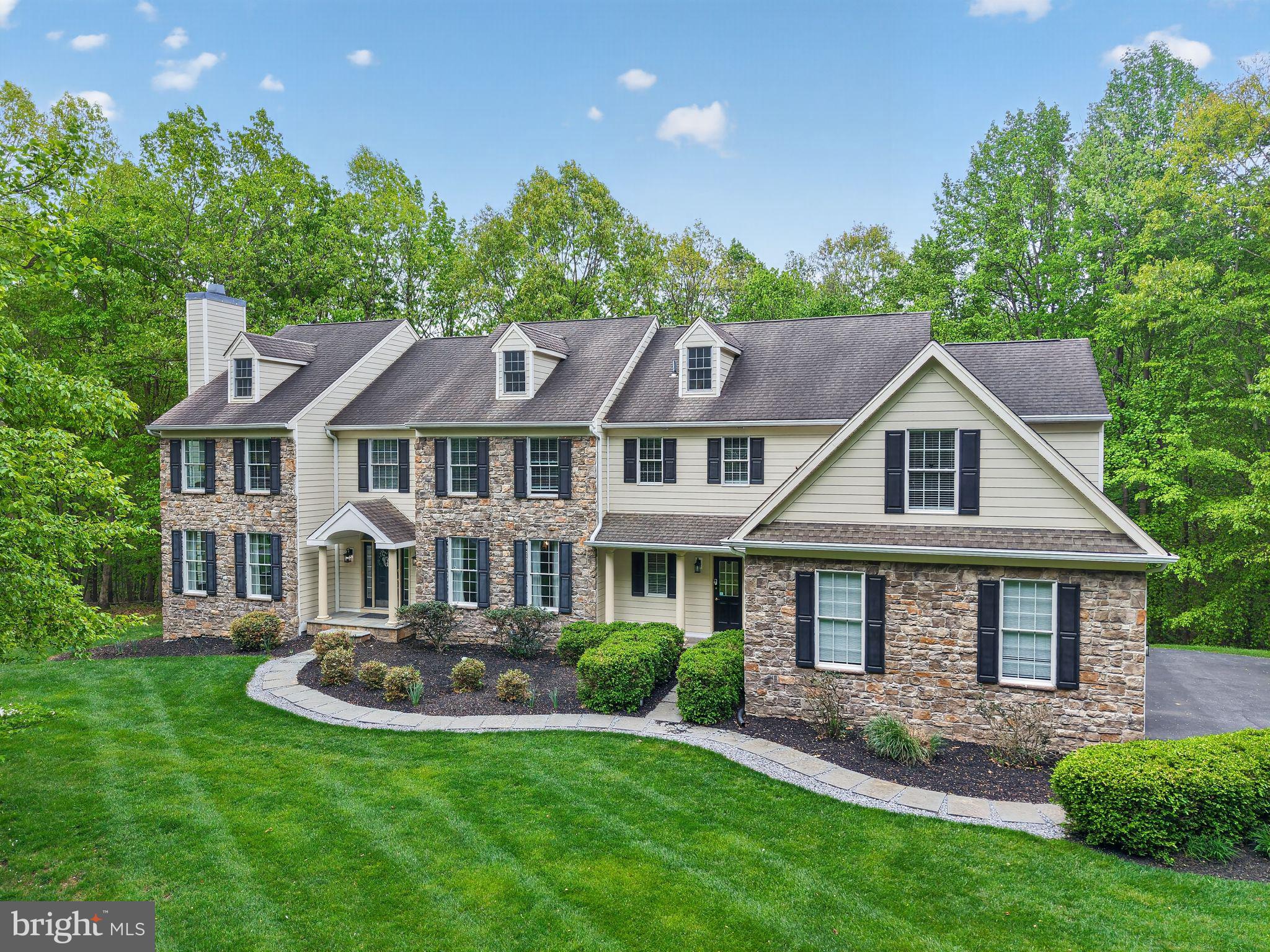 Nestled within the sought after community of Virginia Glen in Brandywine Ridge this extraordinary 5000 sq. ft estate offers far more than a home; it offers a lifestyle. Privately tucked away on 9.5 serene acres along a private drive in the heart of Chester County, this custom Ann Capron, designed residence seamlessly blends luxury living with the beauty of nature, surrounded by mature trees while still enjoying the warmth and connection of an established community.  A timeless exterior of stone and Hardie Board siding creates striking curb appeal, complemented by a newly updated Treks deck with solar accented lighting and expansive stone patio designed for elegant outdoor entertaining and peaceful evenings overlooking the tranquil landscape. Inside, sophisticated craftsmanship and thoughtful design are showcased throughout a five bedroom with four full and two half baths with custom millwork, rich hardwood flooring throughout the main level, custom satin draperies, and refined architectural details at every turn. The gourmet chef’s kitchen is beautifully appointed with stainless steel appliances, a 5-burner gas cooktop, custom cabinetry, and exceptional workspace for both everyday living and entertaining. Formal and informal spaces blend effortlessly, including a gracious formal living room with a wood-burning fireplace and an impressive family great room featuring cathedral ceilings and a dramatic floor-to-ceiling stone wood burning fireplace. Designed for both luxury and functionality, the main level also offers an executive office overlooking the serene rear grounds, a formal powder room, spacious laundry and mudroom with secondary entrance access, and an oversized three-car garage. The second level is highlighted by an exceptional primary suite retreat complete with a private sitting room, custom built-in his and her closets, and a spa-inspired bath featuring dual vanities, an oversized soaking tub, and a large walk-in tiled shower enclosure. Two additional en suites provide privacy and comfort, while two more generously sized bedrooms share a Jack and Jill bath, creating an ideal layout for multigenerational living or extended guest accommodations. Dual zoned with new HVAC units and newly updated water heater. US News and World rated #2 in PA STEM school in the Downingtown Area School District is perfectly positioned near shopping, dining, major routes, and regional rail for convenient travel, this remarkable Chester County estate delivers privacy, luxury, and everyday accessibility in one exceptional offering. This is a rare opportunity to experience refined living surrounded by nature an experience that truly must be seen for oneself.
