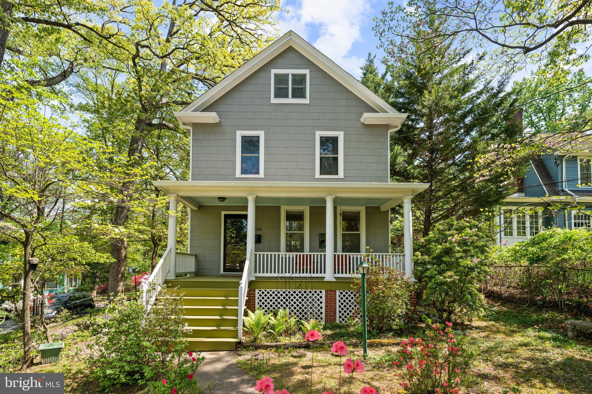 Timeless character, generous scale, and flexible living spaces come together beautifully in this classic Takoma Park home surrounded by mature trees and lush landscaping. Rich original woodwork, hardwood flooring throughout, oversized windows, and gracious room proportions create a warm and inviting atmosphere across multiple levels.

A large covered front porch welcomes you into an expansive main level featuring a spacious foyer, formal living room, oversized dining room, and an extended kitchen with table space that flows seamlessly into the rear family room addition. The thoughtful layout offers excellent everyday functionality while maintaining the home’s original architectural charm. Just off the family room, a rear deck overlooks the private backyard, creating an easy indoor-outdoor connection for dining, entertaining, or relaxing outdoors. A full bath on the main level adds additional convenience and flexibility.

The second level features four bedrooms, including a generously sized primary suite with vaulted ceilings, abundant natural light, a walk-in closet, ensuite bath, and nearby laundry area. Three additional bedrooms and another full bath provide comfortable accommodations with well-proportioned room sizes rarely found in homes of this era.

The attic level offers substantial storage space with future potential, while the expansive lower level includes a large recreation room, additional storage and utility areas, and another full bath, creating exceptional flexibility for hobbies, fitness, workshop space, media use, or future customization.

Outside, the property continues to impress with a detached garage, long private driveway, mature landscaping, and multiple outdoor spaces surrounded by greenery. Ideally positioned near beloved Takoma Park destinations including Spring Mill Bread Company, Cielo Rojo, Takoma Beverage Company, the Co-op, parks, trails, local schools, and Metro access, this is a rare opportunity to own a home with exceptional space, enduring character, and an unbeatable neighborhood setting.