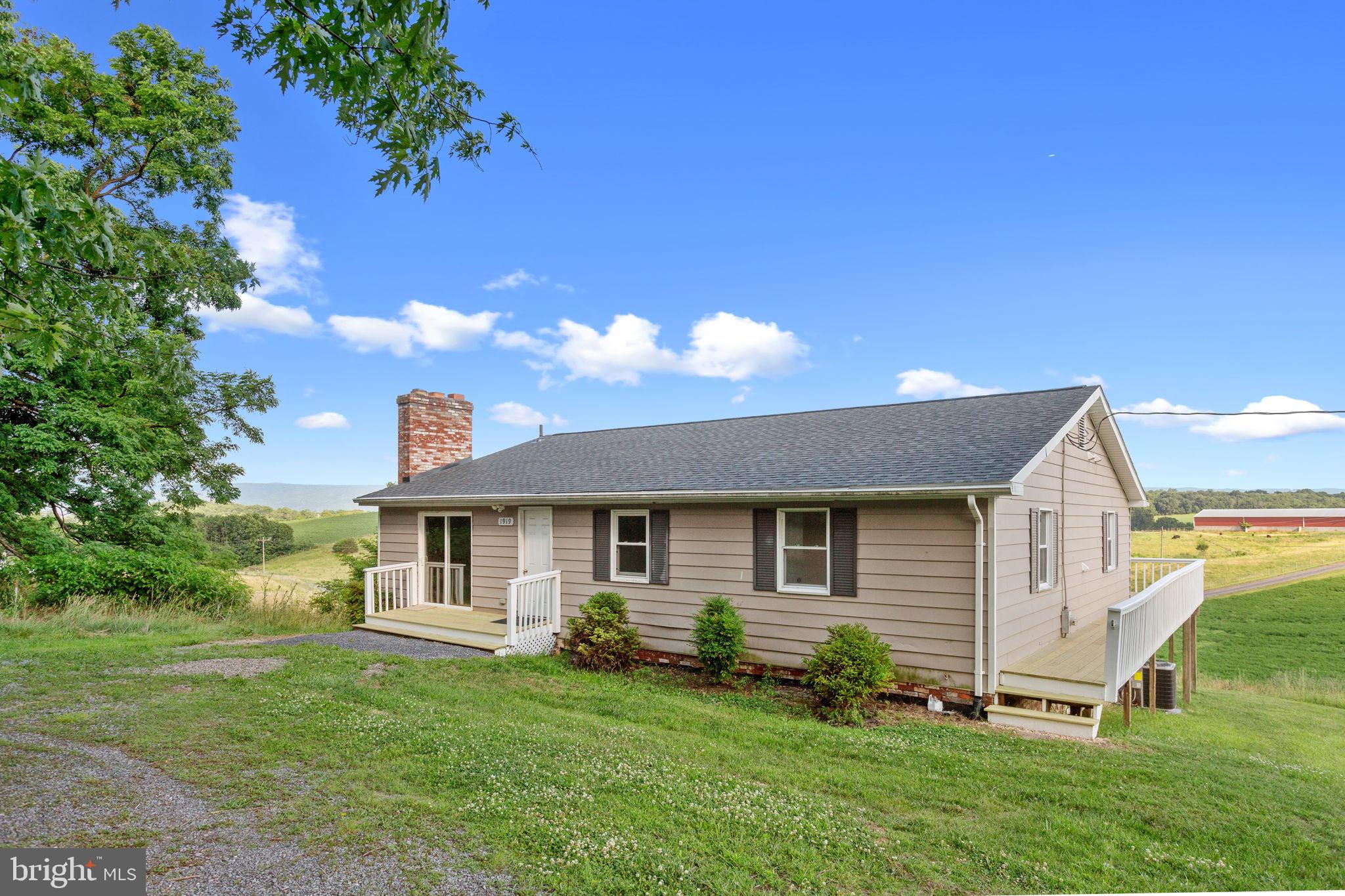 Enjoy peaceful country living just outside the historic town of New Market in this recently renovated 3-bedroom ranch with a full walk-out basement and beautiful mountain views. Relax on the expansive deck with your morning coffee or unwind with a good book while taking in the scenic surroundings. Inside, the spacious kitchen and dining area features a convenient pass-through to the cozy den with a stunning stone wood-burning fireplace. A light-filled living room provides direct access to the deck, creating seamless indoor-outdoor living. The owner's suite offers a private bath with dual-sink vanity and walk-in shower. Two additional bedrooms share a Jack & Jill bath with the laundry.  The full walk-out basement, complete with a second stone wood-burning fireplace, offers outstanding potential for additional finished living space. Conveniently located near the shops and restaurants of New Market and Timberville, the North Fork of the Shenandoah River, caverns, wineries, parks, and I-81 for an easy commute.