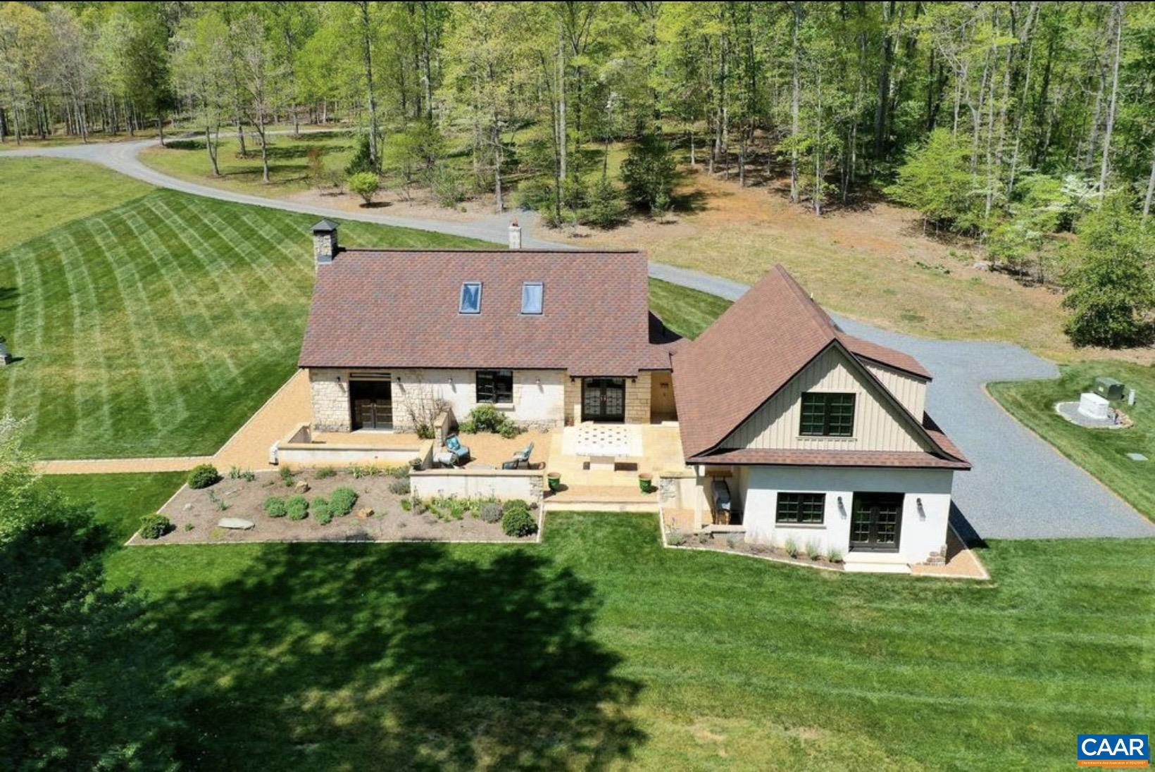 Unique French Provincial estate on 8 private acres in Northern Albemarle County - two fully finished structures offered as one remarkable property. The main residence features a living room with soaring cathedral ceilings clad in tongue-and-groove wood planking, cut-limestone interior walls, and a floor-to-ceiling limestone wood burning fireplace. The designer kitchen stuns with copper ceiling, a full GE Caf� suite in white matte with copper hardware, farmhouse sink, warm-veined marble countertops, and a cast-iron wood stove set into a limestone niche. The primary suite includes a spa bath with soaking tub, carved marble vanity, and a bonus loft that provides storage or extra living space. The adjoining guest house offers a living/dining room with a second limestone gas fireplace, kitchenette, and designer laundry suite. The upper-level features a flexible loft/bedroom area and additional bedroom with vaulted whitewashed ceilings, oak hardwood floors, and a skylight-lit bath. Covered outdoor loggia, outdoor kitchen with Proven�al tile, outdoor shower, and whole-home generator offer incredible outdoor living! Minutes to Charlottesville, UVA, and UVA Health via US-29. Blue Ridge Mountains and Shenandoah National Park nearby.,Glass Front Cabinets,Marble Counter,Quartz Counter,Wood Cabinets,Fireplace in Great Room,Fireplace in Living Room