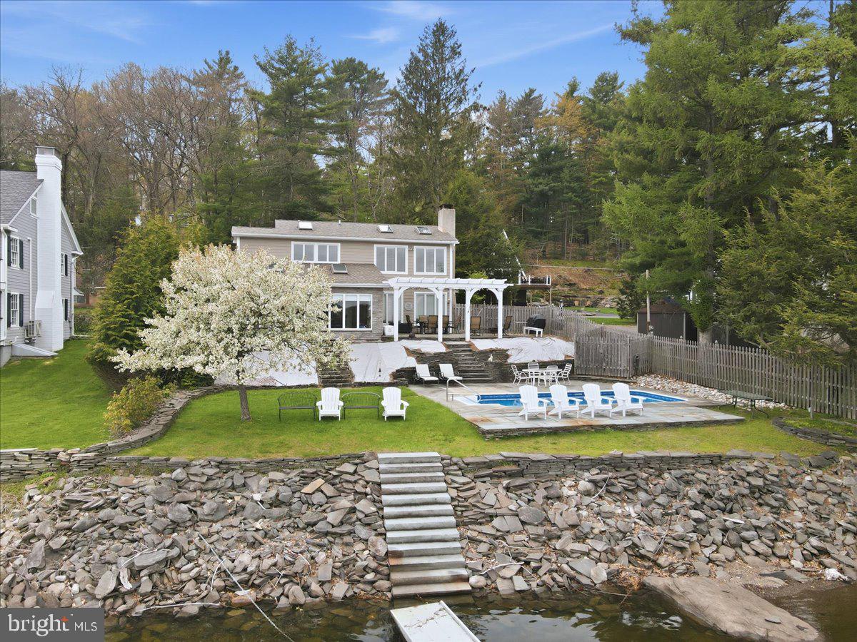 LAKEFRONT HOME IN PRESTIGIOUS SPINNLERS POINT COMMUNITY- 3 Bedroom, 3 bath fully furnished Lakefront home with 75' shoreline and magnificent unobstructed views of Lake Wallenpaupack. This level lakefront includes a 12x24 inground heated pool and 18 x 30 stone patio overlooking the lake. Professionally landscaped grounds add to the spectacular lake views. This lakefront home features a Living room with a stone fireplace, a den, and a 13x22 Florida room with panoramic views of the water. The 3 bedrooms are on the second level with a spacious primary bedroom and bath suite overlooking the lake and pool. A large 2-car garage and additional parking provide plenty of space to accommodate family and friends. A 450 sq ft Bonus room above the garage provides extra living area for entertainment and overnight guests. The large boat dock provides ample space for boat and jet skis. Sold total furnished.