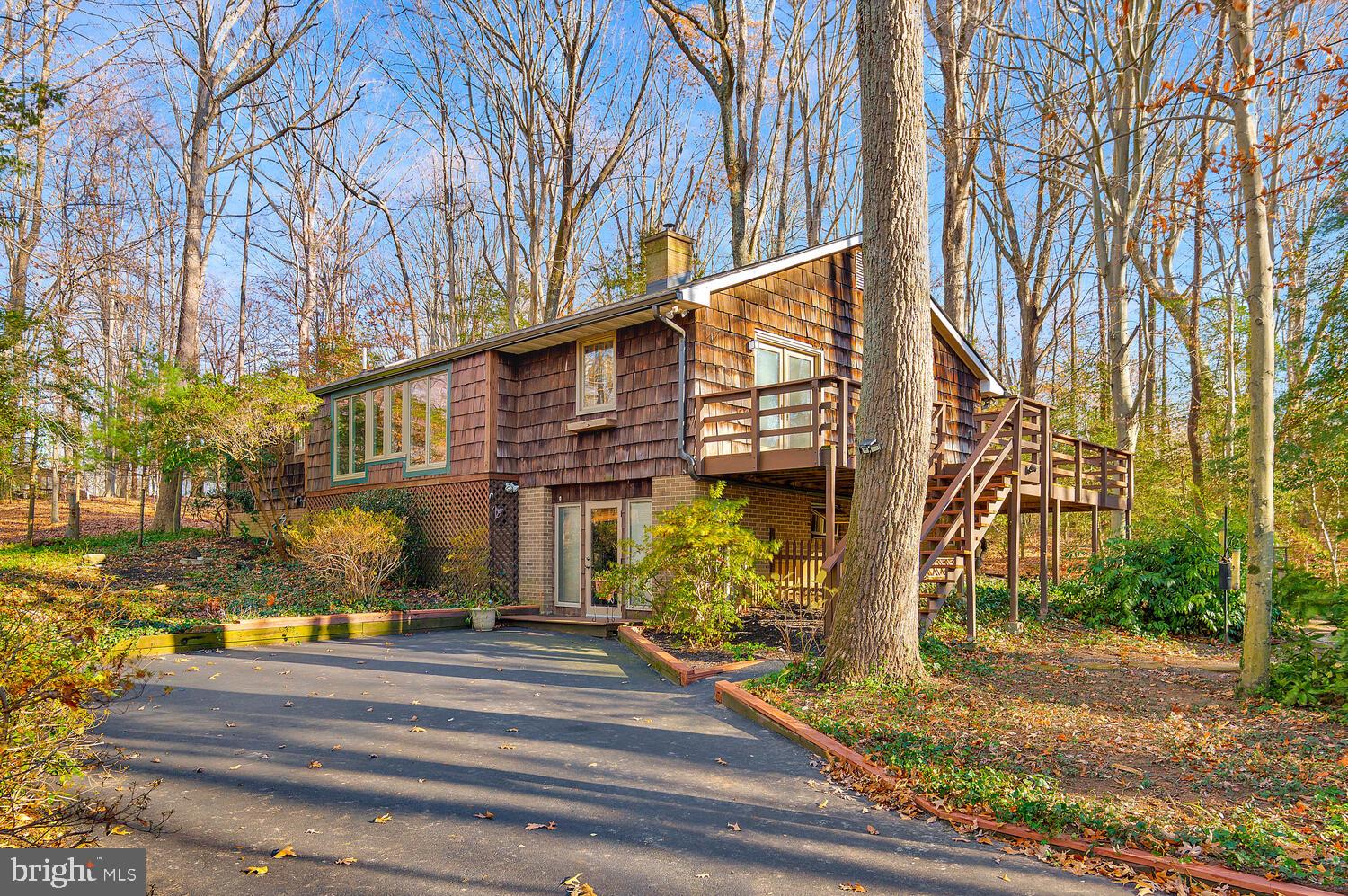 !!!PRICE REDUCED BRING ALL OFFERS!!!  Nestled in the desirable Huntingtown area of mid-Calvert County, this cedar shake shingle residence offers an exceptional living environment. The expansive great room features an elegant wood stove insert, creating an inviting ambiance ideal for family gatherings. The kitchen boasts Corian countertops and extensive cabinetry, facilitating efficient meal preparation and entertaining. The adjacent dining area and deck provide an optimal setting for enjoying meals while overlooking the serene wooded landscape. Recent property enhancements include roof replacements for the house and garage/shed, along with skylight, gutter, and downspout installations within the past two years.
This three-bedroom, two-and-a-half-bathroom home is strategically designed to balance comfort and social interaction. Positioned on a spacious three-acre lot, the property offers privacy and tranquility, enhanced by mature landscaping. Recreational amenities include a fenced basketball/tennis court and horseshoe pit, ideal for family activities.
The predominantly finished basement provides substantial storage and features a versatile entertainment space with a bar, suitable for family gatherings. A partially completed basement bathroom presents an opportunity for personalized customization, further enhancing the home's functional appeal.