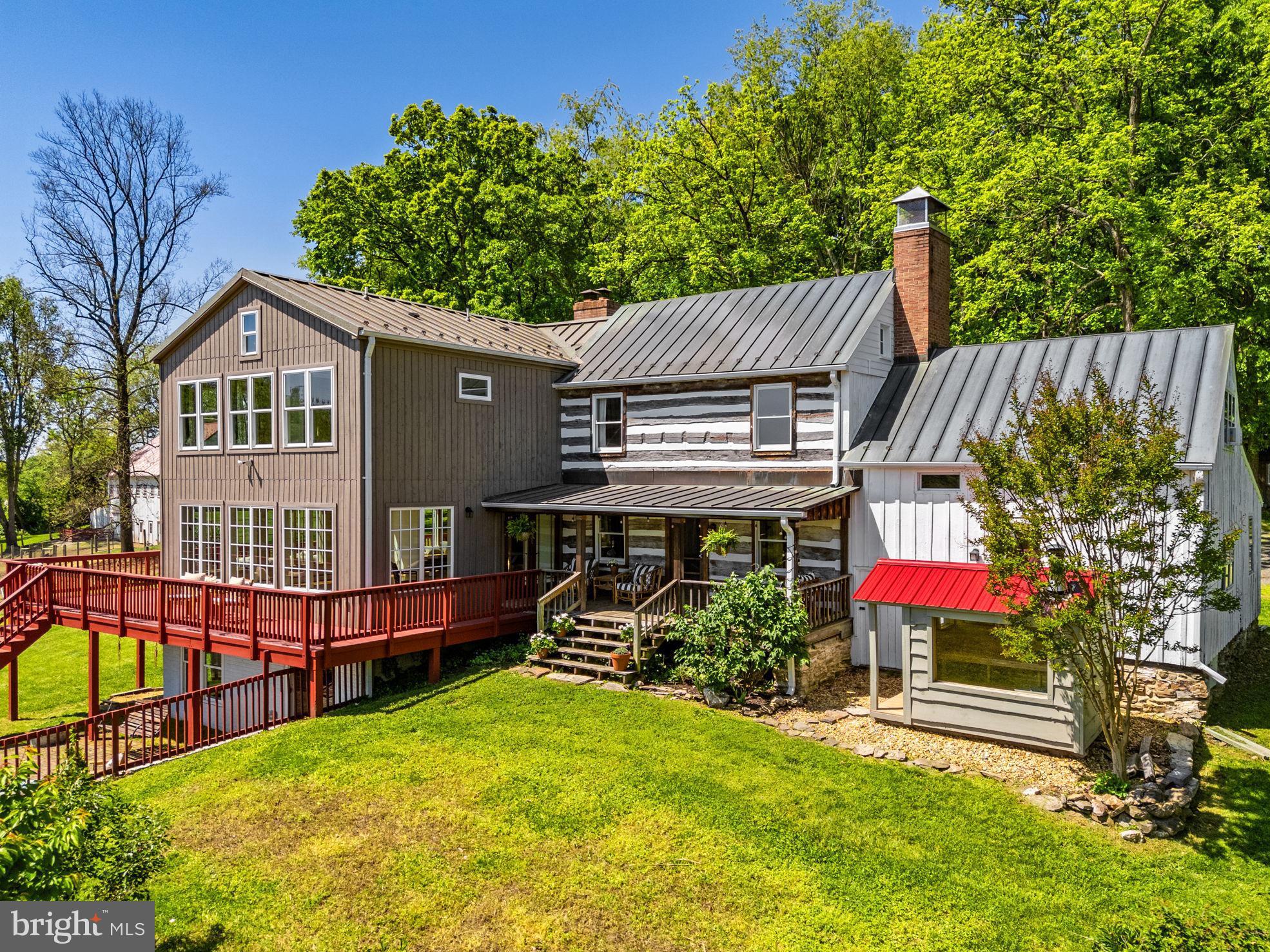 Extraordinary Historic estate  (updated!) on 30 breathtaking acres with VIEWS! Views that make you feel like you're in a tree house! Truly extraordinary property. No HOA and NOT in conservation. Stunning historic home and award-winning Fuog-built bank barn (2022).

Perched to capture spectacular eastern views, the property offers unforgettable sunrises and sweeping vistas stretching to Sugarloaf Mountain. With origins dating back to circa 1820, the original log home has been thoughtfully restored and expanded over time—creating a perfect blend of coziness, character, and modern comfort.  Additions in the 1990s and a stunning 2020 expansion have created a truly move-in ready home that honors its history while delivering today’s lifestyle. From the expansive wraparound deck, family room, and primary suite, you’ll feel immersed in nature—like living in a private treehouse retreat.

The main residence features 5 bedrooms and 3.5 baths, including a new 3-level addition. As part of the new addition, the luxurious primary suite boasts vaulted ceiling, stunning spa-like bath, and walk-in closet with convenient washer/dryer. The beautifully updated kitchen showcases custom cabinetry, a copper farmhouse sink, granite and butcher block counters, and opens seamlessly to a dramatic family/dining room with a wall of windows and wood-burning fireplace. Throughout the home, warmth and character abound with exposed log walls, beamed and vaulted ceilings, wood floors, and three fully functional fireplaces (all cleaned and inspected in 2025).

A charming and private in-law apartment, located in a wing of the original log home, offers exceptional flexibility, complete with its own entrance, kitchen, full bath, loft bedroom, and fireplace—ideal for guests, multigenerational living, or Airbnb potential. The walkout lower level adds even more versatility with a home office, gym, craft room, second laundry, and access to a brick patio with fire pit. Don't miss the private sauna where you relax and recharge while enjoying views of the property!

Outside, the land is as impressive as the home. A picturesque mix of open pasture, woods, and a spring-fed, stocked pond with dock and private beach creates a truly idyllic setting. Approximately 9 acres are fenced for livestock, complemented by electric fencing, three automatic waterers, and run-in sheds.

Equestrian and agricultural enthusiasts will appreciate the award-winning, Fuog-built bank barn (2022), designed for both function and beauty. This 2.5-level structure includes: 4 horse stalls; 6 sheep stalls with adjustable-height and removable walls; a milking station; pig pen with concrete floor and automatic waterer;  climate-controlled tack room and feed room; flexible storage or event space which could be finished off to create four additional horse stalls; hay loft; wash stall with hot and cold water;  and equipment storage. Enjoy a turn-key working farm or an extraordinary party barn:)

With no HOA, the possibilities here are endless. Additional features include a copper roof (metal on the addition), water treatment system, two water heaters (including tankless), wiring for a generator, and over $700,000 in recent improvements. Recent updates include: 3-level addition (2020), new bank barn (2022),  HVAC (2018), tankless hot water heater/boiler (2019), newer well pump, septic tank pumped (2025).

If you're looking for land, views, charm and freedom, this is the place for you! Don't miss this incredibly unique opportunity.