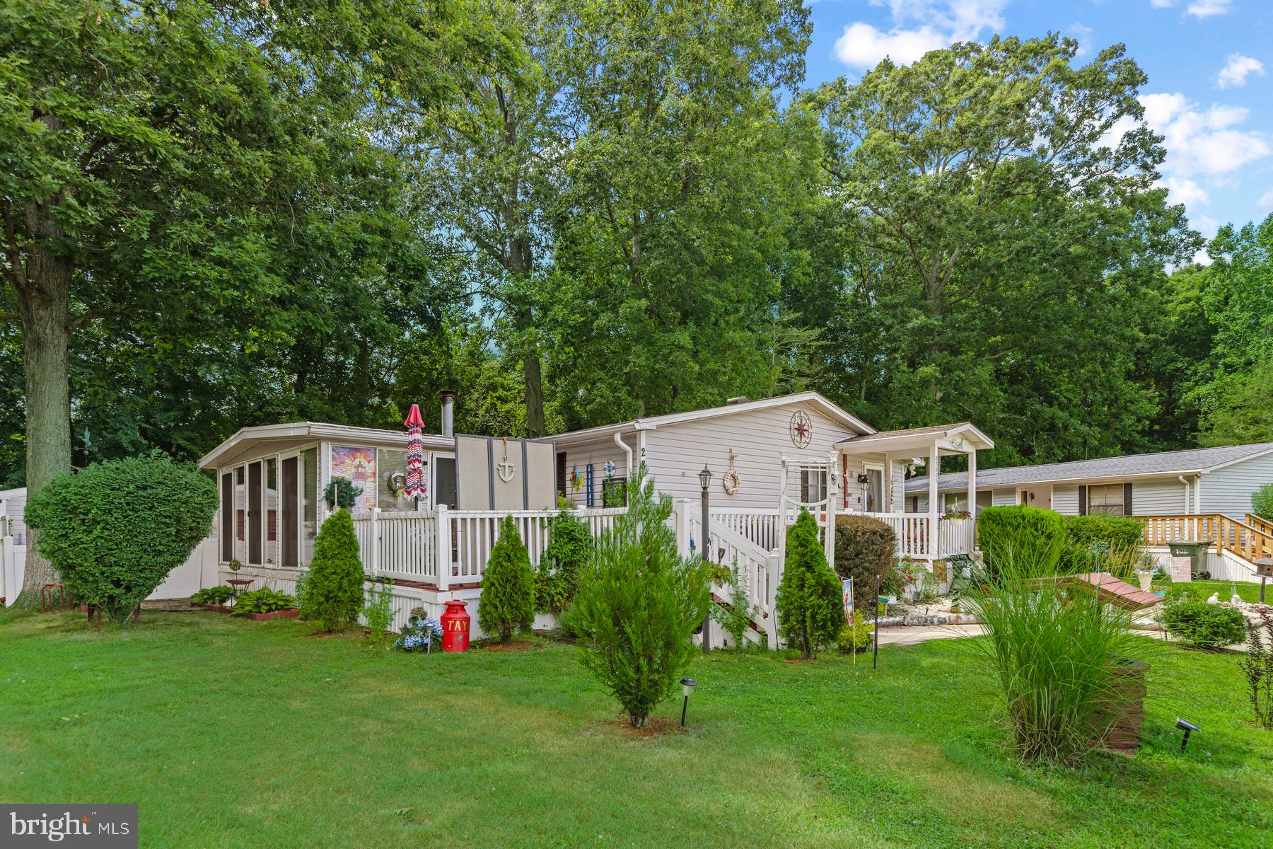 Some homes check boxes. This one changes your pace of life.
Tucked into Angola Estates, a waterfront community along Burton Prong, a wide navigable river that flows directly to Rehoboth Bay, this beautifully updated 3-bedroom, over-1,800-square-foot home delivers the space, privacy, and lifestyle that make Delaware beach living genuinely livable year-round. You are about 15 minutes from Route 1 and all the energy of the Lewes and Rehoboth Beach corridor: outlet shopping at Tanger Outlets, waterpark fun at Jungle Jim’s, movies at Midway, and a restaurant scene that rivals any major city. The beaches are roughly 20 to 25 minutes away. But when you come home, you come home to quiet, trees, and water. The open-concept living area centers on a stunning stone fireplace with a classic mantle and custom built-in cabinetry, the kind of room where people naturally gather. A patio slider opens to a bright sunroom, which flows directly to the back deck and patio. The split-bedroom floor plan offers real privacy: two guest rooms comfortably fit queen beds, while the owner's suite accommodates a king. The owners added extra windows in the dining room and a bedroom, so natural light fills the home throughout the day. At the rear, a versatile bonus room with its own private entrance, storm door, and direct porch access is ready to become whatever you need: a home office, hobby room, craft space, or comfortable retreat for visiting family. Updates are thorough: new flooring throughout (no carpet anywhere), refreshed bathrooms (including a beautiful step in shower in the owner's bath), new countertops, updated lighting and ceiling fans, and mostly LED ceiling fixtures. The roof was replaced in 2015. Storage is genuinely abundant, with a kitchen pantry, dedicated linen and coat closets, two large walk-in closets, and a dining room hutch with mirror. Outside, the home sits on one of the more private lots in the community, with more space between neighbors than most, a fenced backyard bordered by woods, and professional landscaping. Hot and cold outdoor water faucets are already in place for anyone wanting to add an outdoor shower. The oversized two-section shed features a garage door and concrete floor on one side, ideal for a golf cart, with plenty of room on the other side for beach gear, lawn equipment, and everything else that comes with coastal living. Community amenities include two swimming pools, a marina with floating docks, a boat ramp, a fishing pier, a fenced boat and trailer storage yard for boats, RVs, jet skis, and more, basketball and tennis courts, playgrounds, a community center with  organized activities, and generous common areas throughout. Park approval is required and includes credit, background, and income verification. Financing is available through lenders specializing in leased land properties.