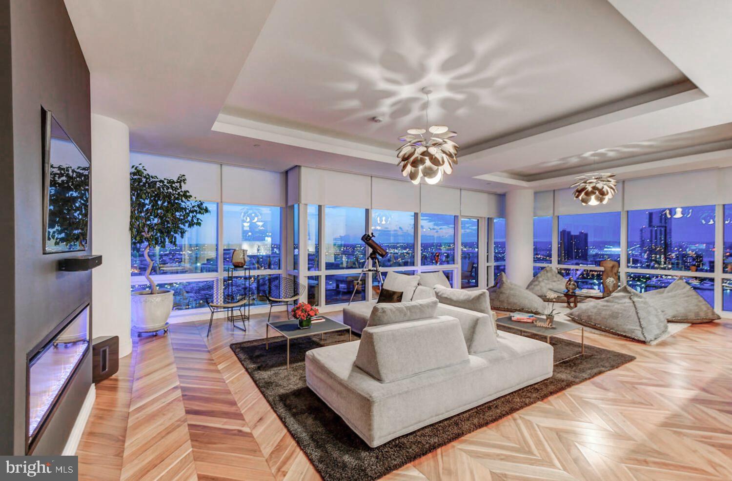 Welcome to the Four Seasons Private Residences in the heart of Harbor East, where luxury, location, and lifestyle converge.  From the 23rd floor, this gorgeous 2-bedroom, 2.5-bathroom residence offers spectacular  views of the Inner Harbor and marina and the Baltimore city skyline through  floor-to-ceiling windows.  This refined residence features rich walnut herringbone flooring, a gas fireplace, and high-end finishes throughout. The gourmet kitchen is outfitted with elegant cabinetry, a gas cooktop, wall oven, huge island with breakfast bar, and elegant quartz countertops. The adjacent dining area and wet bar with sink and wine fridge are ideal for entertaining or for a quiet night at home.  The primary suite includes a custom walk-in closet and a luxurious marble bathroom with double sinks, a large soaking tub, and separate shower. A second bedroom, also nicely sized, offers comfort and privacy for guests or family.
Enjoy your morning coffee or evening wine on the private balcony, and enjoy the shimmering waterfront and Baltimore skyline.  As a resident, you’ll have exclusive access to the private 28th-floor amenity level featuring an indoor saltwater infinity pool, sauna, outdoor deck, fitness center, meeting rooms, and lounging areas — plus a dog-walking area for your furry family members.  You’ll also enjoy full access to all hotel amenities, including the outdoor pool and valet services.  This property comes with one dedicated parking space in the garage with easy resident access.   The Four Seasons features four on-site restaurants, and many amazing dining options just a short walk away in Harbor East and Fells Point.  Shopping, parks, harbor activities, museums, and miles scenic waterfront walkways are all close enough to enjoy every day.  Experience luxury living at the Four Seasons, it’s more than a residence, it’s a lifestyle.