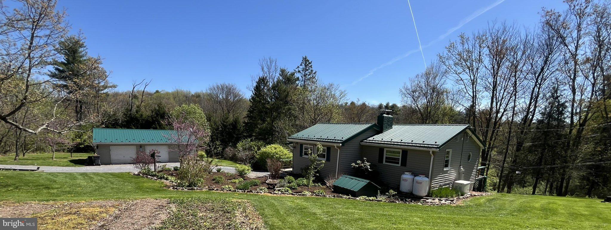 **A Private Haven on Purdue Mountain: Close to Nature and Bellefonte Area Charm**

Welcome to your own slice of rural Central Pennsylvania paradise, nestled high on Purdue Mountain in the sought-after Bellefonte Area School District. This charming ranch-style home offers an extraordinary blend of privacy and flexible living across a magnificent 1.75-acre wooded lot.

As you step inside, you’ll immediately appreciate the thoughtful flow of the main level. The inviting open floor plan seamlessly connects the family room and the eat-in kitchen, creating an ideal setting for gatherings.  But the truly unique feature of this home is the incredible convenience of **two separate kitchens **. The lower-level kitchen is functionally equipped with an electric oven/range & Cherry Cupboards, ceramic tile flooring and hardwoods and the Main level kitchen has a new gas stove and laminate flooring, microwave, and an extra refrigerator, making meal preparation easy. and a total of 2 bedrooms and 2 full bathrooms—an exceptional layout for in-law quarters,  guests, or multi-generational living.

Anchoring the cozy atmosphere are two fireplaces, perfect for tranquil evenings on the mountain. The living space extends naturally to the outdoors through multiple decks, which are central to the home’s charm. Retire to the primary bedroom and step onto your own secluded **upper deck**, where the current sellers loved unwinding to quietly observe the wildlife at dusk. Enjoy the other 2 decks for entertaining, grilling, or just hanging outside. Start your mornings savoring a cup of coffee while watching the sun rise.

The lower level is home to a fully finished daylight basement with a walkout entrance, providing versatile additional living space for guests, a game room or relaxation.

Beyond the home, the 1.75 acres is a certified natural wonder. Stroll through your private sanctuary and discover a magnificent tulip tree, abundant blooming flowers, and numerous fruit-bearing plants, complemented by a spacious garden area ready for planting fresh vegetables.

Practical updates include newer metal roofs and siding on the house and garage, which add modern value and curb appeal. While this charming home retains its cozy character, many renovations were completed from 2017 to 2025 to introduce updated amenities. 220amp in garage, 220 amp in house, well water, on-site septic, and a Generac generator wired to the home.

Located in a welcoming community near local parks, close to shopping, 3 hospitals, 10 miles from Penn State University, you gain access to a friendly atmosphere and quality educational support through the Bellefonte Area School District. 

**Contingency Notice:** The Closing on this home will be contingent upon the seller finding suitable housing.
