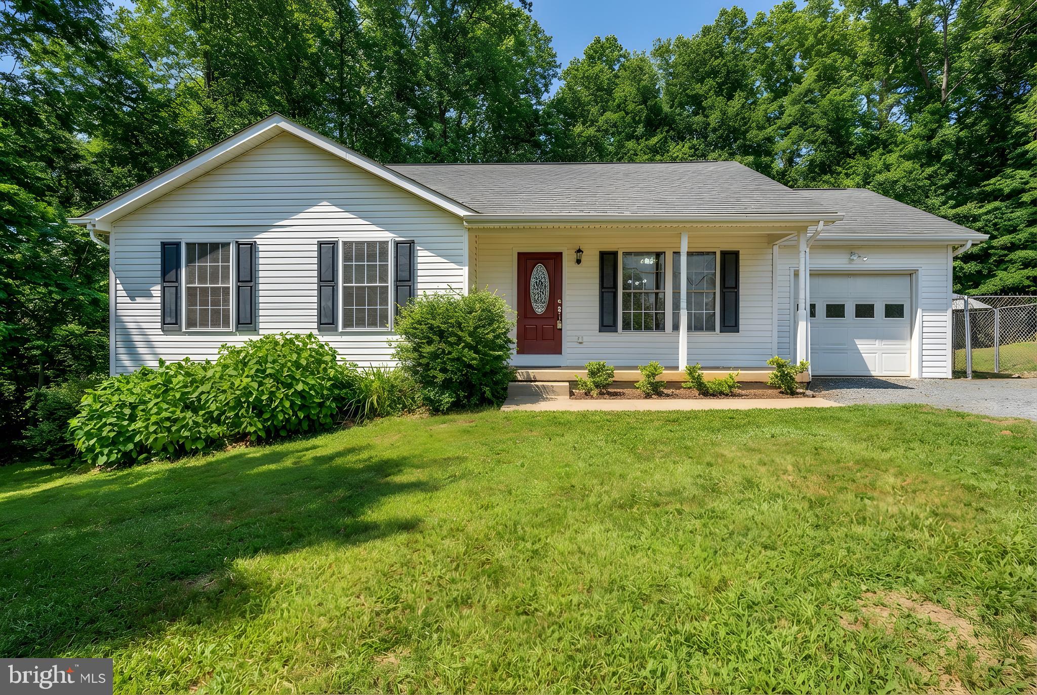 Completely remodeled and showing like new, this beautifully updated home is tucked away at the end of the street on a private, wooded lot. Offering desirable single-level living with a finished basement, the home welcomes you with an inviting front porch and quality hardwood flooring throughout most the main level.

The family room features cathedral ceilings and a ceiling fan, creating a bright and open living space. The kitchen is equipped with stainless steel appliances and offers ample room for a dining table, with direct access to a spacious rear deck—perfect for enjoying the peaceful, private setting.

The primary bedroom includes an en suite bath, while generously sized secondary bedrooms provide flexibility. One main-level room features custom built-ins, ideal for a home office. Both full baths on the main level have been recently remodeled with brand-new flooring, vanities, fixtures, and lighting. All electrical outlets throughout the home have been replaced.

The finished basement adds exceptional living space, including a recreation room, a legal bedroom, an additional flex room suitable for an office, exercise, or hobby room, and a full bath with new vanity and flooring. Additional updates include upgraded lighting fixtures, fresh interior paint, a water treatment system, and front doors leading to the side yard.

The freshly painted one-car garage features newly completed epoxy flooring. A large dog run with ground-level wiring is included. Enjoy the tranquility of a rural setting while being just minutes from shopping and everyday conveniences.