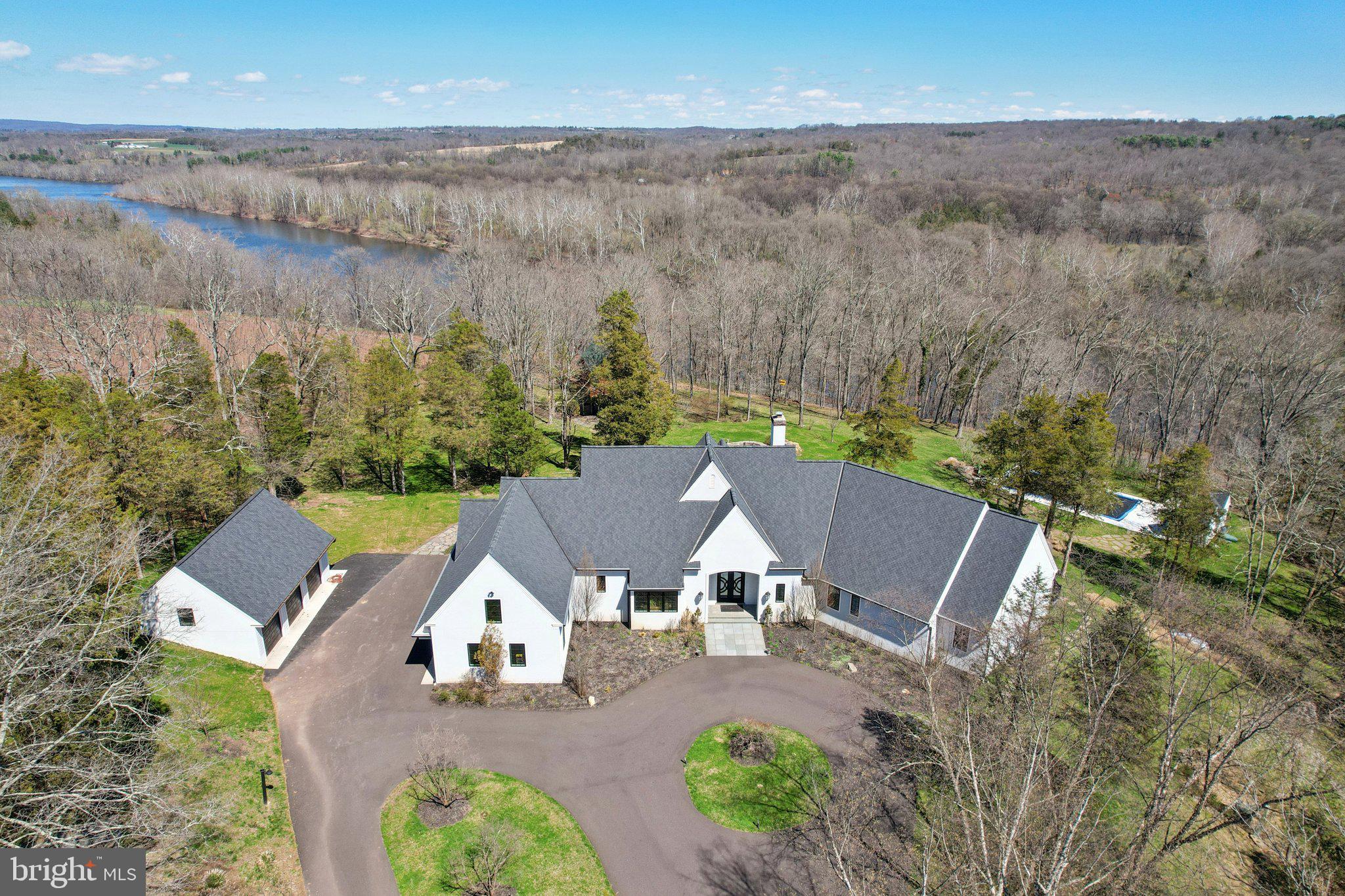 Set at the end of a private lane, the long meandering driveway  flanked by mature trees in a rustic landscape is "Cedar Hill Reserve".  This one of a kind custom built home has panoramic views above the Delaware river and sweeping uninterrupted sightlines for miles across the rich rolling landscapes of Bucks and Hunterdon counties.   Enter through the front door and your eyes are immediately drawn the two story bank of French doors & windows framing the bucolic setting. The large open floor plan combines comfortable living space with a sophisticated chef style kitchen, large island, plumbed antique worktop coffee station and two tier stone stacked wood burning fireplace.  The formal dining room, with custom millwork is just steps from the kitchen and offers plenty of room for guests and a bank of windows overlooking the lush tree line. The main floor continues with an expansive home office surrounded by built in book shelves and work station with views of the river.  The master suite is an oasis with multiple custom finished walk-in closets, sumptuous master bath, vaulted ceiling and French doors that open to a private deck for morning coffee or evenings counting the stars. There are two more generous en-suites on the main floor and a great view from any window. The two story wing of this estate style home provides a full suite for guests with ample room for storage and possible additional finished space.  There is a three car attached and a brand new three car detached garage  with electric and water plumbed in. The sunny backyard is a recreational retreat with an in-ground pool & pool house overlooking the river valley and heated tree house with wrap around deck with views across the neighboring vineyard and miles across the river. The timeless mature landscape completely surrounds the sleek & sophisticated country home. Just a short drive to New Hope, Frenchtown, Easton and well within commuting distance to NYC.  Schedule your private tour today!
