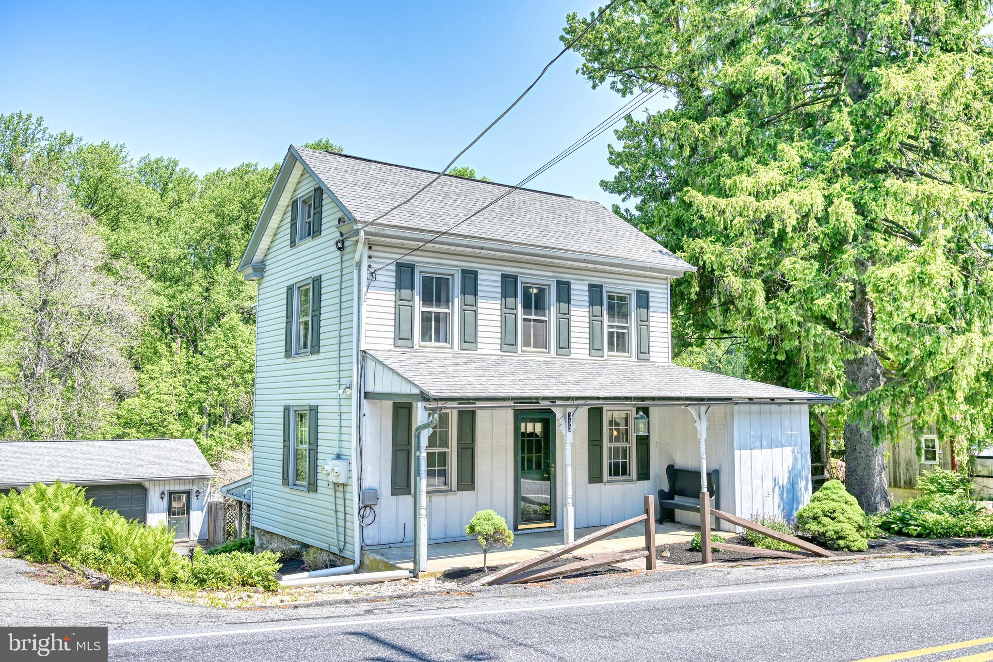 Nestled in the picturesque rolling hills of Berks County, just moments from the landmark Historic Galen Hall in Wernersville, this charming home effortlessly blends rustic appeal with modern comfort. Step inside to a welcoming layout that greets you with a formal dining room to your left and a spacious eat-in kitchen to your right. The kitchen is an inviting gathering space featuring a walk-in pantry, striking planked wood ceilings, and ample room for a large dining table. Just beyond, the living room serves as a cozy country retreat, showcasing exposed beams, beadboard ceilings, and an incredible brick fireplace with a propane log insert. Upstairs, the expansive primary suite features a private en-suite bath and a walk-in closet. The upper level also includes a second private bedroom and a versatile walkthrough room at the landing—perfect for a home office, hobby room, reading nook or 3rd Bedroom. Downstairs, the finished lower level provides even more living space, boasting a family room with a built-in bar, a second propane fireplace, a full bathroom, a dedicated laundry room, and a newly installed propane furnace. Outdoor living is a dream in this serene South Mountain setting. A welcoming front porch, side deck, and rear patio all overlook a beautifully landscaped yard filled with lush ferns and a peaceful, tree-lined backdrop. As a fantastic bonus, the property includes an oversized, heated two-car detached garage. Whether you are a car enthusiast, need abundant storage, or dream of running a home workshop (as it was utilized for many years), this space delivers. With all these features—plus the peace of mind of a brand-new roof—this Conrad Weiser gem won't last long. Don't delay; call to schedule your showing today!