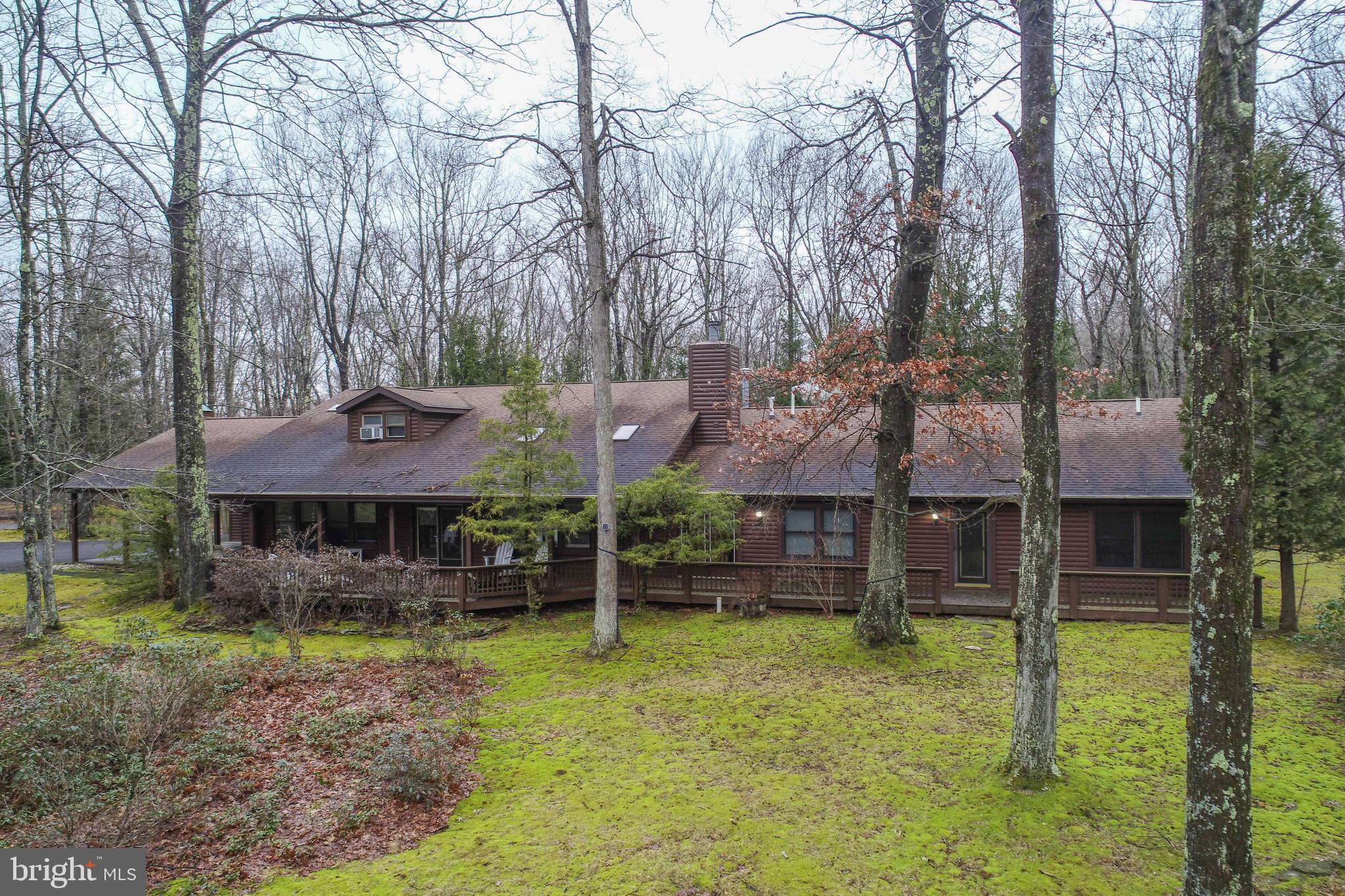 One-of-a-kind Deep Creek retreat with proven income potential! Set on 1.27 private wooded acres in the desirable Gleanings community, this distinctive log-sided lodge offers over 4,000 sq ft of flexible living space and has been an established, successful Airbnb with even stronger potential for full time investors. The main residence features three spacious ensuite bedrooms, a dramatic great room with vaulted ceilings, and a stunning stacked-stone wood-burning fireplace that creates true mountain-lodge ambiance. The open-concept kitchen with center island functions well today with excellent potential for future updates. A rare and valuable bonus is the attached, fully handicap-accessible guest house offering two bedrooms, one bath, a and living area—ideal for guests, multi-generational living, or maximizing rental income. Garages have been fully finished to help maximize additional living spaces perfect for providing that needed separation during large group stays. Surrounded by privacy and nature yet just minutes from Deep Creek Lake amenities and the Wisp Ski Resort,  this property is a standout opportunity as a primary residence, vacation escape, or high-performing investment.