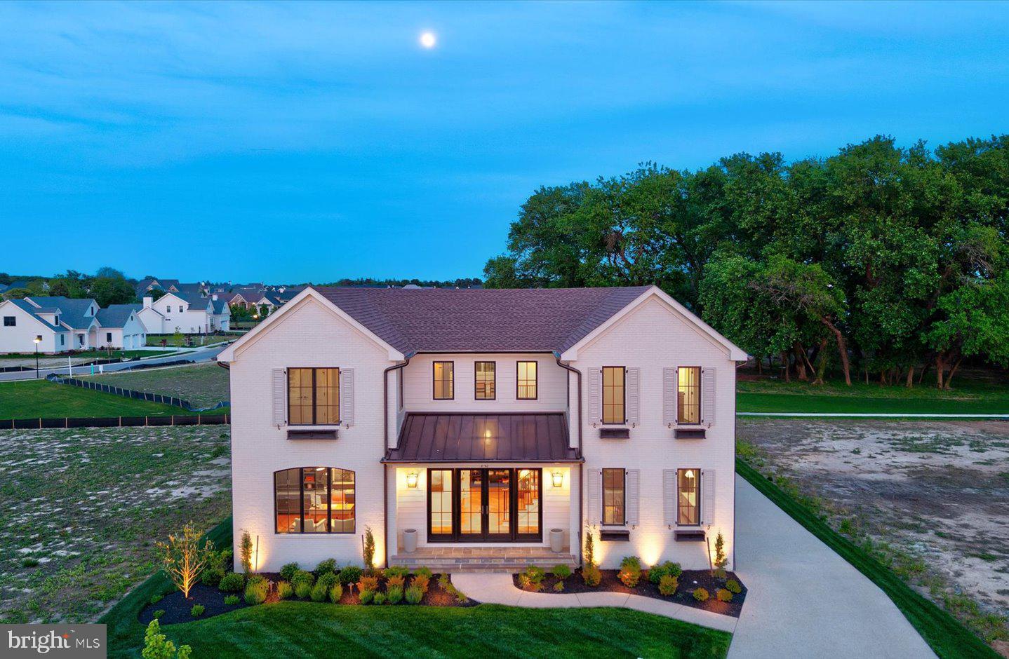 Located in the heart of historic Lewes within the desirable new community of Olde Town, this exceptional Garrison Homes custom build offers the perfect balance of modern luxury and timeless design. Spanning approximately 4,395 sq. ft., this 5-bedroom, 4.5-bath residence is a showcase of fine craftsmanship and thoughtful detail. A striking glass-front entry welcomes you into a sun-drenched, open-concept interior featuring custom white oak finishes and refined architectural elements such as handcrafted pocket doors, arched openings, and paneled hallways. At the heart of the home, the gourmet kitchen commands attention with a herringbone-patterned floor, built-in shelving, oversized island, and a hidden walk-in pantry. Top-tier appliances include dual Sub-Zero Designer Series paneled units, a 48” Wolf gas range, dishwasher, and an ice maker—perfectly suited for both everyday living and entertaining. Designed to accommodate a variety of lifestyles, the home offers a luxurious first-floor primary suite with a private screened porch, as well as an upstairs guest suite with its own laundry. A full unfinished basement with 3-piece plumbing rough-in provides abundant storage and the potential for future expansion. Outside, a white brick façade with dark bronze accents creates stunning curb appeal, complemented by beautifully landscaped grounds, elegant walkways, a detached garage, and an outdoor shower. This remarkable home embodies the signature quality and craftsmanship of Garrison Homes, all just one mile from Lewes Beach, Cape Henlopen State Park, and the shops and restaurants of downtown Lewes.