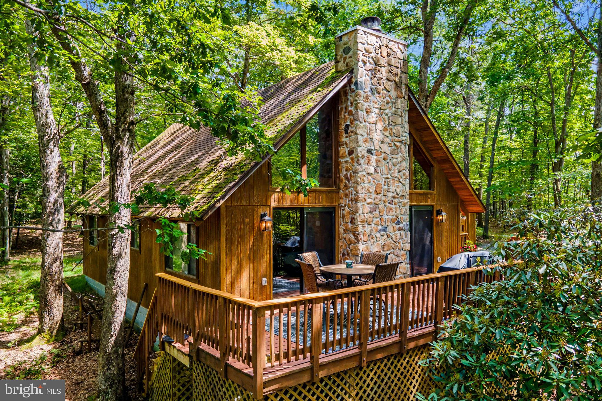 Welcome to your Deep Creek Lake retreat in Sky Valley. This 3-bedroom, 2-bath A-Frame offers the perfect blend of mountain character and modern comfort, complete with lake access in a quiet, scenic setting. Inside, the open-concept layout is highlighted by vaulted ceilings, a loft overlooking the main living area, and a beautiful stone fireplace that creates a warm, inviting focal point. Large windows bring in natural light, giving the home a bright and airy feel throughout. Offered fully furnished, the home is move-in ready, including a fully renovated kitchen, refreshed fixtures, furnishings, and two beautifully updated bathrooms. Step outside to enjoy the expansive wrap-around deck—ideal for entertaining or relaxing after a day on the lake. A fire pit adds the perfect touch for year-round enjoyment. Lake access includes a peaceful cove with sandy beach and private boat launch, making it easy to enjoy everything Deep Creek Lake has to offer. Ask about the opportunity to acquire a boat slip through the HOA! The detached garage provides plenty of room for vehicles, lake gear, and outdoor equipment. Bonus room to be finished in May. Just minutes to Wisp Resort, state parks, dining, and 1 mile from Thousand Acres Golf Course. A turnkey opportunity in a sought-after location—ready to enjoy from day one. Schedule your showing today.
