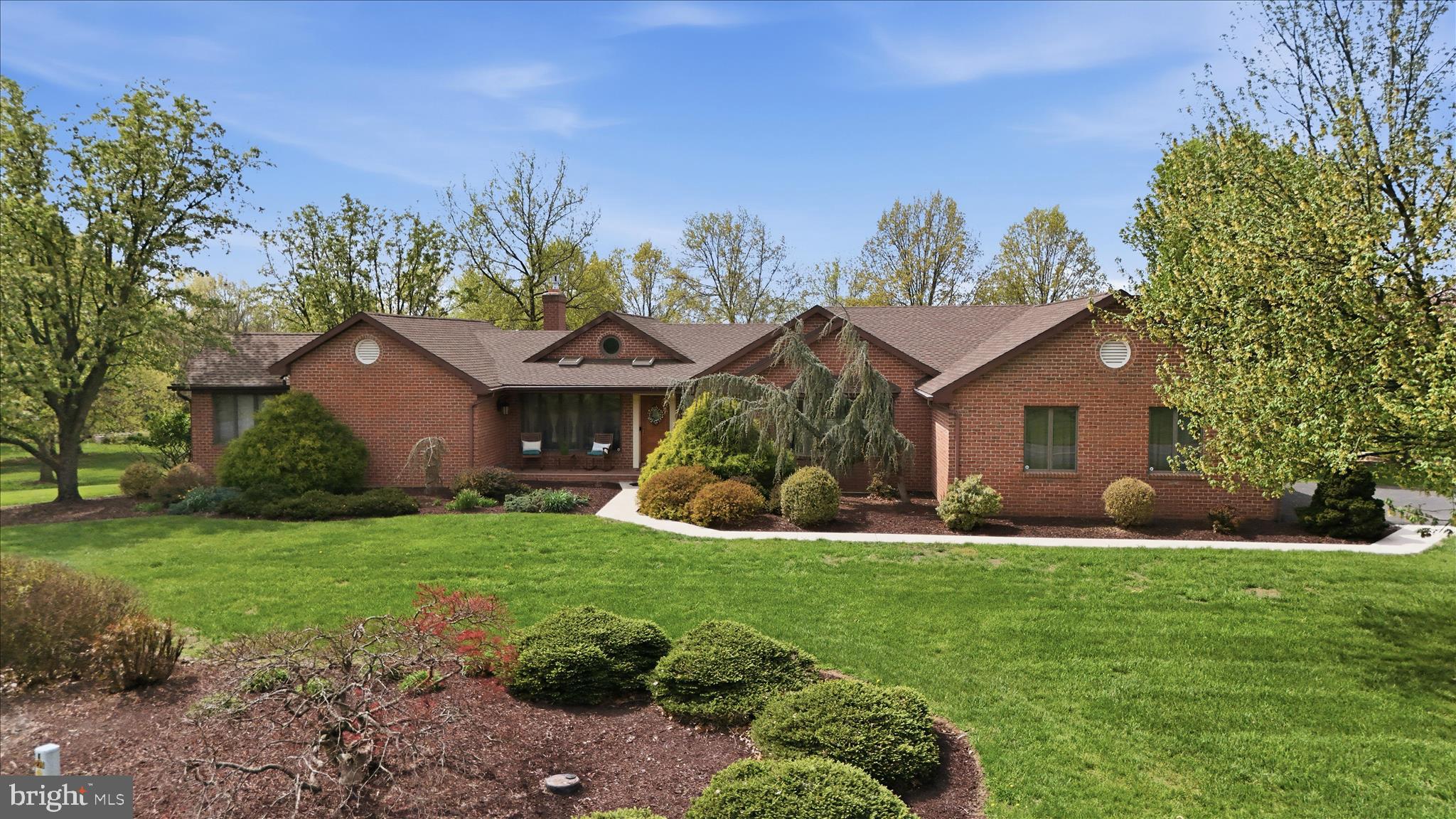 This sprawling brick rancher in  Laurich Town Hill Estates is loaded with exceptional features and timeless appeal. As you enter you will immediately notice the elegant yet warm and inviting living room with gas fireplace, hardwood floors, vaulted ceilings and expansive windows that showcase the views of the gorgeous 2-acre lot.  The open floor plan flows seamlessly into the formal dining room which has a tray ceiling and opens to the gourmet kitchen featuring custom cabinetry, stainless steel appliances, and granite countertops. Highlights include a 6-burner Jenn-Air gas range with pot filler, double wall ovens, tile backsplash, lighted cabinetry, a large island with sink and dishwasher, plus a bright bay window, make this space as functional as it is beautiful. Entertaining is effortless with the HUGE adjoining pantry—perfect for all your storage needs. The cozy family room offers a charming brick gas fireplace, while the spacious enclosed sunroom provides the perfect place to relax and unwind.
The main-level primary suite is a true retreat, featuring a tray ceiling, expansive en-suite bath with double vanities, a walk-in tiled shower, and a two-seat hot tub set in a large bay window—your own private spa experience! A generous walk-in closet completes the suite. An open staircase leads to the fully finished lower level, offering two large bedrooms with walk-in closets, a full bath, and an inviting rec room complete with custom bar, granite countertops, wine fridge, and a kegerator. Additional spaces include an exercise room and a den with built-in shelving and extra storage. This home truly shines outdoors as well, set on a 2-acre lot perfect for enjoying peaceful evenings. Car enthusiasts and hobbyists will love the attached two-car garage plus an additional detached two-car garage—plenty of room for all your toys and tools. Additional features include two radon mitigation systems, security system, central vacuum, surround sound and two water heaters. A truly classic home—perfect for everyday living and unforgettable entertaining! Square footage and room sizes are estimated.