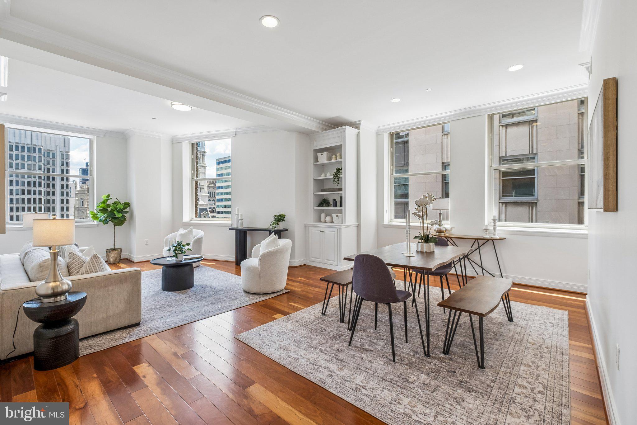 Enjoy a luxurious pampered lifestyle from this impeccable corner two-bedroom two-bath residence with BREATHTAKING VIEWS of City Hall and Love Park, convenient ON-SITE PARKING and STORAGE in Center City’s premier full-service building. Experience the grandeur of custom millwork and crown moldings, and modern finishes and amenities, all with the convenience of DIRECT ACCESS TO THE TRAIN and easy access to I-76 and I-95. Spacious living and dining areas showcase gleaming hardwood floors, soaring ceilings, and walls of oversized windows with an abundance of natural light. Two well-proportioned bedrooms with excellent closet space are set apart for privacy. Spa-like bathrooms feature stone counters and sinks, ceramic tile floors, chrome fixtures, and vanity cabinetry with storage. The gourmet kitchen includes stainless steel appliances, sleek Silestone countertops that provide ample counter space, lots of cabinets and spacious breakfast bar. Large in-unit laundry room with a full-size washer and dryer, coveted on-site parking space, private storage unit, and a multitude of discerning upgrades complete this exceptional residence at The Phoenix. Association fee includes 24-hour concierge and doormen, one of Philadelphia’s largest breathtaking rooftop terraces with seating and grilling stations, a state-of-the-art fitness center, a weightlifting room, a library area, an oversized resident lounge, and a conference room. Conveniently situated in the Rittenhouse Square and Logan Square areas, this pet-friendly home is steps from fine dining, boutique shopping, cultural destinations, and 30th Street Station. Easy access to UPenn, Drexel, HUP, and CHOP, inside access to Suburban Station, and close to highways.