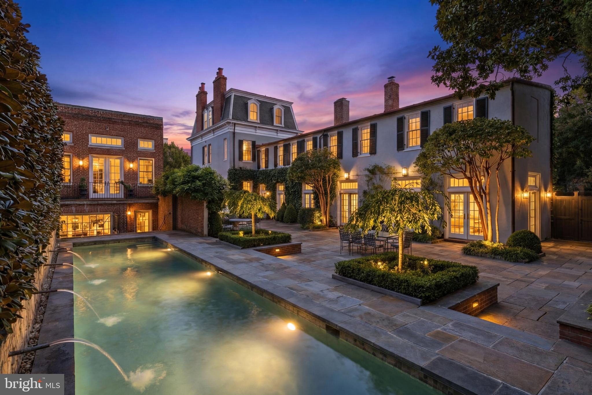 Set along one of Georgetown’s most established residential blocks, 3117–3121 O Street NW presents a rare townhome compound offering exceptional scale, privacy, and versatility. Originally built in 1900 and comprehensively remodeled in 2019, the property encompasses approximately 7,200 square feet across a primary residence and a fully integrated guest house.

The main residence honors classic Georgetown architecture while delivering a highly livable, thoughtfully modernized layout. Formal living and dining rooms anchor the main level, each defined by fireplaces and gracious proportions. The kitchen opens directly to the central courtyard through French doors, creating a seamless flow between interior and exterior spaces. Designed for both everyday living and entertaining, the kitchen is outfitted with Wolf and Sub-Zero appliances, multiple refrigeration zones, dual wine storage, and a breakfast area with its own fireplace.

Outdoor living is a defining feature of the property. The private, landscaped courtyard is centered around a lap pool with an automatic cover and is complemented by fountains, flagstone patios, and an outdoor kitchen, forming a tranquil retreat rarely found in the heart of the city.

The upper levels of the main house are anchored by a dedicated primary suite wing featuring dual walk-in closets and a spa-style bath with a skylight, soaking tub, and dual water closets. Additional bedrooms span the upper floors, many with fireplaces, offering flexibility for guest accommodations, home offices, or private studies. The lower level is equally well-considered and includes a recreation room, gym, theater with seating for eight, and a laundry room.

The guest house, accessible both internally through the lower level and via a separate exterior entrance, adds a meaningful layer of adaptability. With its own living space, kitchenette, bedrooms, bathrooms, and direct garage access, it functions seamlessly as guest quarters, extended family accommodations, or a private work-from-home residence. A two-car attached garage with EV charging, along with additional driveway parking, further distinguishes the offering and provides a level of convenience seldom found in Georgetown.

Throughout the home, systems and infrastructure have been carefully curated, including multi-zone HVAC, whole-house audio, automated blinds, integrated home automation, and security systems.

Defined by scale, outdoor living, and flexibility, 3117–3121 O Street NW represents a rare opportunity to own a timeless Georgetown compound designed for modern city living.