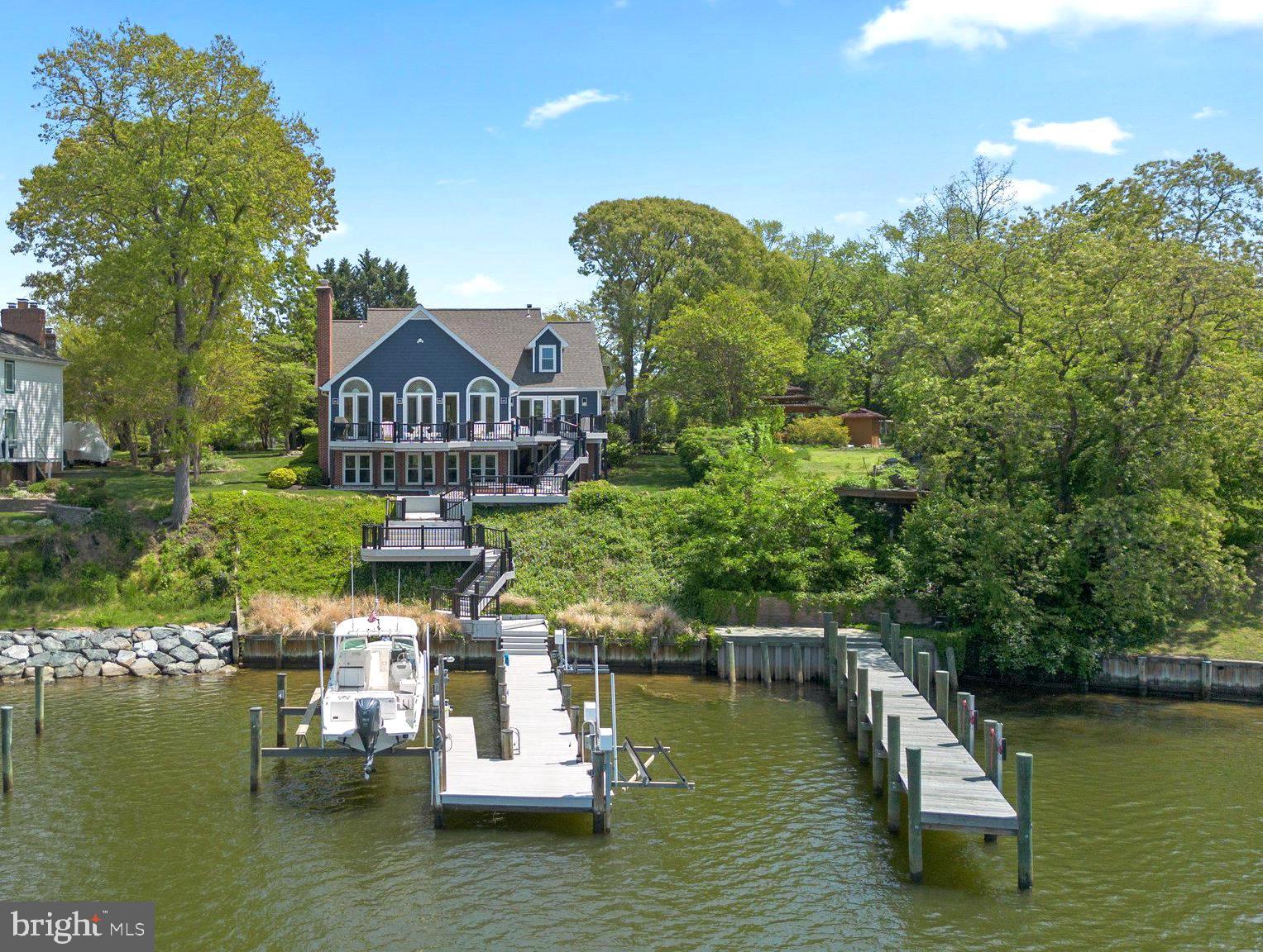 Luxury Waterfront Home in Ulmstead Estates - Fabulous Views & Location! Wake up to stunning panoramic water views every day in this custom home. Situated on nearly half an acre of beautiful waterfront, this property is an entertainer's dream, featuring multi-level decks perfect for outdoor gatherings. Offering 60 feet of pristine water frontage, a private pier with lift perfect for the boating enthusiast. Step inside to discover 3 stunning levels boasting 4 spacious bedrooms with 4 full and 1 half bathrooms. The open-concept main level is designed to maximize the incredible views, with each room offering a picturesque backdrop. Sleek kitchen with quartz counters, massive center island with seating, built in appliances and open to the great room with vaulted ceilings and walls of windows. The dining room is complemented by a built in wet bar, beautiful cabinetry and beverage fridge. A main level primary suite with double doors to the top tier deck overlooking Forked Creek and a spa inspired bathroom built for relaxation with freestanding soaking tub and gorgeous glass enclosed tiled shower. Travel upstairs to find 3 additional bedrooms and 2 beautifully renovated bathrooms. The lower level offers even more, including an additional living room, home gym, sauna with full bathroom and flex space making an ideal game room. This exceptional property offers the perfect blend of luxury, comfort, and waterfront living combined with the unmatched amenities in Ulmstead Estates- multiple beaches, marinas, tennis courts, pool with swim team, horse stables plus a vibrant, active community- you do not want to miss the opportunity to make this your forever home! Schedule your private tour today!