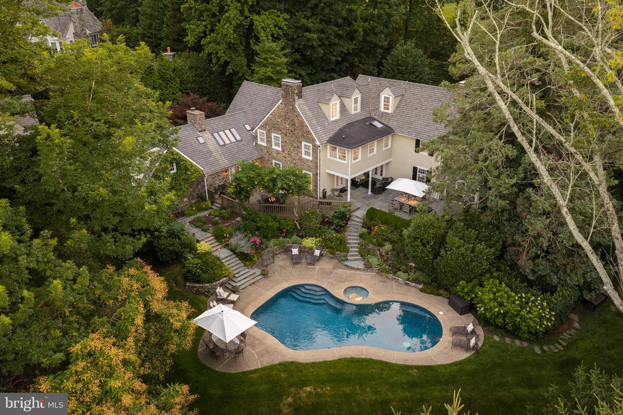 SOME HOMES SIMPLY HAVE A SOUL.....
Quietly tucked among the winding lanes of the prestigious Ardrossan section of Villanova, the Gold Coast of Radnor Township, 847 Lesley Road has been gracefully welcoming family and friends for nearly a century. Offered for the first time in over 40 years, this extraordinary three-story stone Colonial is more than an architectural landmark—it is a home filled with laughter echoing from summer afternoons by the pool, holiday gatherings that spilled from one gracious room to the next, and generations of cherished memories waiting to be passed to those who will write its next chapter. From the moment you arrive beneath the canopy of mature trees, there is an unmistakable sense of peace. The house feels as though it has always belonged here, perfectly settled into its breathtaking surroundings where architecture and nature exist in complete harmony. Lovingly expanded and thoughtfully reimagined over the years, every addition has honored the home's timeless character while creating the effortless luxury today's lifestyle demands. Sunlight pours through oversized windows and French doors, illuminating beautifully proportioned rooms where refined millwork, gleaming hardwood floors, and timeless architectural details create spaces that are both elegant and wonderfully inviting. The main living spaces unfold with remarkable ease, each room flowing naturally into the next before opening through countless French doors to wraparound stone terraces, an expansive deck, and one of the most magical backyards on the Main Line. Here, lush gardens, sweeping lawns, towering specimen trees, and a sparkling pool create a private sanctuary that feels worlds away. It is easy to imagine children spending endless summer days in the pool, cocktails shared on the terrace as the sun begins to set, and family dinners lingering long into warm summer evenings beneath the glow of lantern light. Designed to evolve with every stage of life, the home offers five to six bedrooms, four full baths, and three half baths. A private office with its own entrance is tucked above the attached garage, creating an ideal work-from-home retreat. Completing this remarkable estate is a detached two-car garage with a beautifully appointed apartment above—perfect for extended family, an au pair, guests, or a private studio. Homes like this are extraordinarily rare. They cannot be recreated, only cherished. Rich in history yet thoughtfully refined for modern living, 847 Lesley Road offers that elusive feeling every buyer hopes to find—a home that is as beautiful as it is welcoming, as sophisticated as it is comfortable, and one that instantly feels as though it has always been yours. This is more than a home. It is a legacy. It is a lifestyle. It is where the next generation of unforgettable memories begins. SHOWINGS BEGIN ON WEDNESDAY JULY 15th!! Interior Photos coming & Square footage does not include apartment above 2 car detached Garage ( 1,279 sq ft)