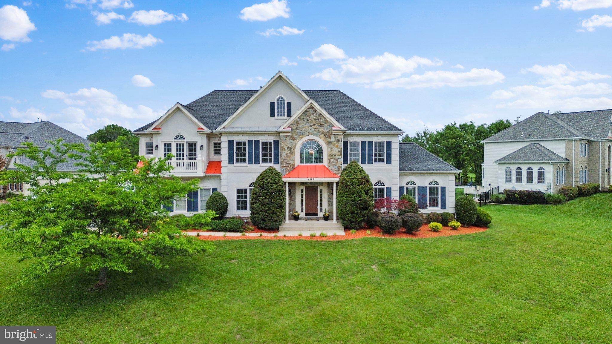Nestled within the prestigious Hampshire Greens Golf Course community, this exceptional Colonial residence offers nearly 7,000 square feet of beautifully finished living space on a landscaped 0.72-acre corner lot. Ideally positioned with convenient access to Washington, D.C., Baltimore, and major commuter routes, the home combines timeless design with modern comfort.

Freshly painted with thoughtful updates throughout, the home welcomes you with a dramatic two-story foyer featuring soaring ceilings, crown molding, wood floors, and an elegant dual staircase. The home’s open-concept design and expansive windows fill the interior with abundant natural light, creating an airy and inviting atmosphere throughout. The expansive two-story family room is anchored by a marble corner fireplace, offering a warm and impressive gathering space.

Designed for both everyday living and entertaining, the gourmet kitchen features granite countertops, a large center island with cooktop, abundant cabinetry, a butler’s pantry, spacious breakfast area, and brand-new stainless steel appliances including a wall oven, microwave/convection oven combination, and dishwasher. The seamless flow between the kitchen and family room creates an ideal setting for entertaining and daily living alike.

The main level also includes a formal dining room, elegant living room, private office, powder room, and a stunning sunroom with cathedral type ceilings and walls of windows. Rich architectural details such as crown molding, wainscoting, and hardwood flooring add sophistication throughout the home.

Upstairs, four spacious bedrooms each with their own full bathroom access, provide comfort and flexibility, including multiple full bath configurations and a Jack-and-Jill bath. The impressive primary suite offers a true private retreat, featuring a generous sitting area, two walk-in closets, and French doors that open to a private balcony. The spa-inspired bath includes double vanities, a soaking tub, and walk-in shower.

The fully finished walk-up lower level offers exceptional versatility with a large recreation and entertainment area, full bath, three additional oversized rooms, and extensive storage space. Ideal for a media room, fitness area, home office, hobby space, or guest accommodations, the possibilities are endless.

Step outside to enjoy a peaceful backyard setting backing to parkland and walking trails, creating a serene outdoor retreat. Community amenities include tennis courts, golf facilities, and scenic paths for recreation and relaxation. A side-entry garage and expanded parking area add everyday convenience.

Offering a rare blend of elegance, functionality, natural beauty, and refined living space, this remarkable residence presents an exceptional lifestyle opportunity in one of the area��s most sought-after communities.