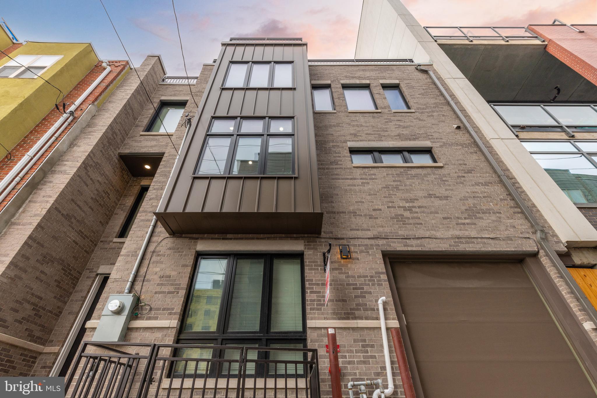 Welcome to 1347-49  Kater St! This stunning 4,700 sq. ft. sits on a double wide lot and is located in a highly sought-after area of Bella Vista, offering convenience to restaurants, gyms, and stores. Surrounded by new construction homes, this property provides easy access to Center City, I-76, I-95, & Airport.  Less than 5 min walk to South St.  with plenty of public transportation options. Step inside the grand foyer, adorned with beautiful engineered hardwood floors, and discover a large two-car garage, a half bathroom, and a bedroom. On the second floor, you'll find the European kitchen equipped with a massive island, Cafe Appliance package, and custom cabinetry. The kitchen flows seamlessly into the dining area and living room, which opens up to a large private balcony, perfect for hosting friends and family. Make your way to the third floor, where you'll be greeted by a walk-in laundry room and three bedrooms. Two of the bedrooms feature spacious closets and en-suite bathrooms with high-end finishes. The fourth-floor master suite boasts a front balcony, a large walk-in closet, and a master bathroom complete with a double vanity and a free-standing tub, all showcasing high-end finishes. Head up to the oversized rooftop, ideal for entertaining guests on those beautiful nights. The lower level offers additional finished living space, including a sixth bedroom or office with a full bathroom. Ample storage space is also available. 8-year tax abatement, included. NEW CONSTRUCTION only lived in for 1 year. This is an amazing deal for double wide lot 32x39 with 4500+ of finished SQFT. True 2-car parking , 4 Outdoor spaces, Elevator, and located in the heart of the city.