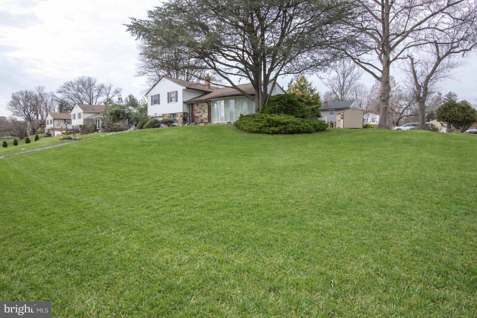 Split-level home • Huntingdon Valley • Remodeled kitchen 2016 • Gas fireplace • Pella windows • Lennox HVAC 2021 • Private patios • Walk-up attic • 0.4 mi to Lormer Park •  Shopping: 0.8 miles • Hospitals 1.2 miles • Regional rail: 1.4 miles

This beautiful corner property is located on a quiet street in the sought after June Meadows neighborhood. Welcome to 1180 Ballytore Road a well-maintained split-level home offering 3 bedrooms, 2 ½ baths with garage and thoughtful updates throughout. The living room features a dramatic floor-to-ceiling bow window and a vent-free gas fireplace added in 2015, while the formal dining room enjoys garden views through an oversized window.
The kitchen was fully rebuilt to the studs in 2016 and includes 42-inch custom cabinetry, a granite peninsula, Pergo flooring, recessed lighting, and a Pella sliding glass door opening to the Private rear patio opening to a private rear patio surrounded by mature landscaping. Steps connect to a lower patio off the family room, creating an easy indoor-outdoor flow.
Upstairs, the primary bedroom offers dual closets and a private bath, joined by two additional bedrooms with ceiling fans, newer doors, and custom built-ins for storage or workspace. A full hall bath with vanity and tub serves the additional bedrooms. Hardwood floors are present beneath carpeting on the first and second levels. A walk-up attic provides convenient storage or future flexibility.
The lower level adds versatile living space with a family room, updated powder room, exterior access to the backyard, and a carpeted utility area with washer and dryer(2021), leading directly to the attached garage.
Notable upgrades include Pella windows in 2016, a Lennox gas HVAC system in 2021, a roof with custom gutters and downspouts in 2017 with a 30-year warranty, a 200-amp electric panel replaced in 2015, a 40-gallon hot water heater in 2020, driveway excavation in 2016, Pulse custom alarm system in 2016, automatic outdoor sprinkler system, and an outdoor storage shed.
Conveniently positioned approximately 0.4 miles from Lormer Park, 0.8 miles from shopping, 1.2 miles from hospitals, and 1.4 miles from regional rail, this home combines thoughtful updates with a practical layout in a desirable Huntingdon Valley setting.