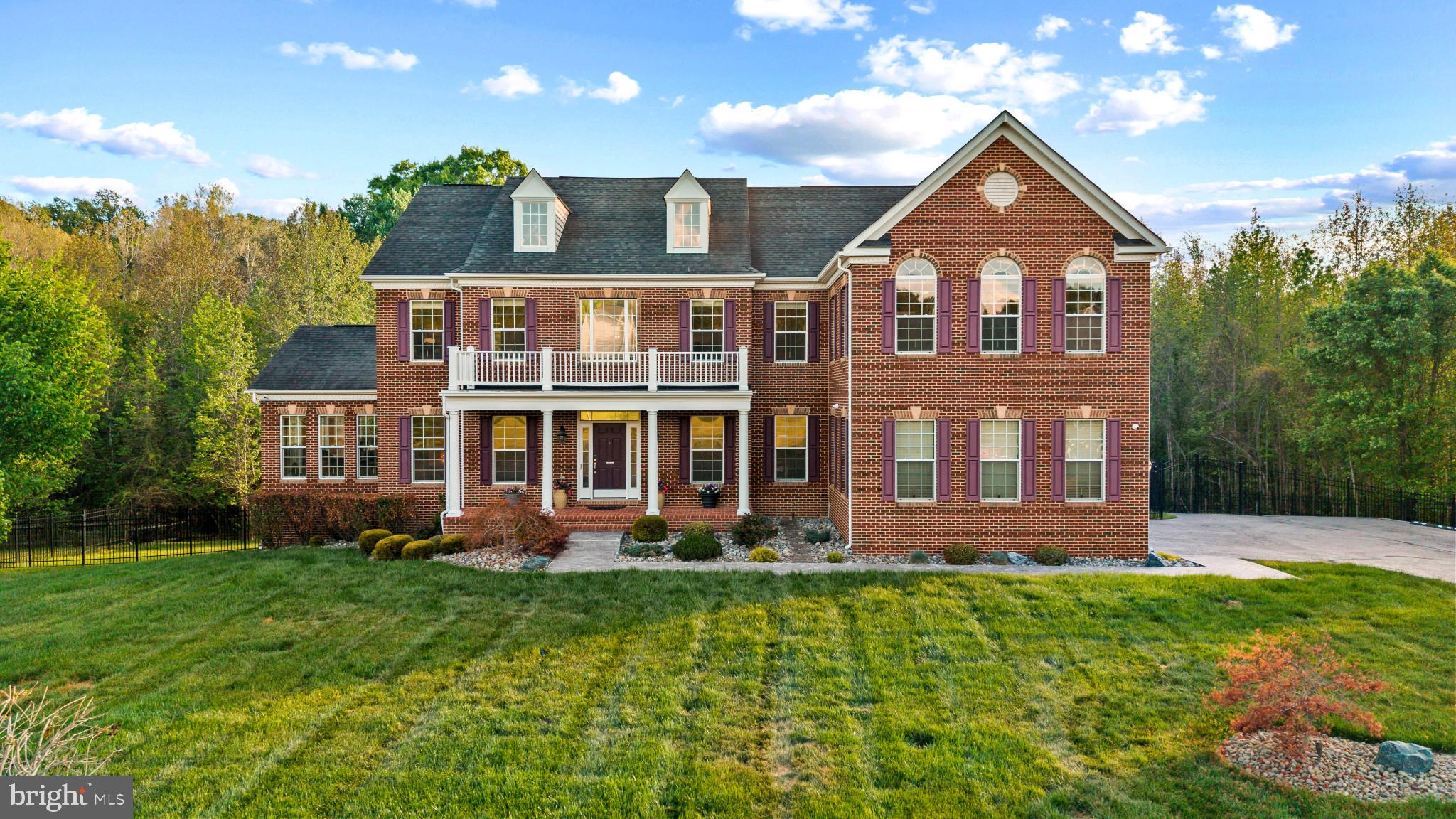 Welcome to your private estate retreat in the prestigious Windsong community, perfectly situated on nearly 9 acres of wooded grounds, offering a rare sense of seclusion and tranquility at the end of a quiet, no-outlet street.

This 4-bedroom, 5-bath Caruso Kingsport model offers over 7,300 square feet of finished living space, enhanced by a full rear bump-out across all levels, creating a more open and elevated layout.  
A grand two-story foyer makes an immediate impression with marble flooring, shadow box detailing, crown molding, and a dramatic dual staircase with an upper-level catwalk, setting the tone for the refined architectural design throughout. 

The main level serves as the heart of the home, featuring a two-story great room with ceramic tile flooring, coffered ceilings, a marble and glass tile gas fireplace, refined shadow box detailing, and floor -to-ceiling Palladian-style windows that fill the home with natural light.

The open-concept design flows seamlessly into the chef's kitchen, showcasing an oversized island, top-of-the-line appliances, a sunroom, a butler’s pantry, and more.  Additional main-level features include a formal dining room, living room, full bathroom, private office (or optional 5th bedroom), and a conservatory living area offering both comfort and versatility.

The upper-level private owner’s suite provides a true retreat, featuring a striking three-sided fireplace, spacious sitting areas, dual walk-in closets, and a spa-inspired bathroom. 3-generous-sized secondary bedrooms included well-appointed baths, with one offering a Jack-and-Jill layout. A full laundry room with cabinetry, adding everyday convenience, completes the 2nd level.

The fully finished walkout basement extends the home's living space, offering a wet bar, fitness room, full bath, and additional unfinished spaces, ideal for a home theater, wine cellar,   in-law suite, guest suite, or other extended living options.  

Outdoor living is equally impressive, with the sunroom leading to the main deck with stairs to the backyard and patios – ideal for gatherings.  On the opposite side of home, the conservatory opens to a more private deck with a hot tub, a mounted TV, and a retractable awning – perfect for quiet relaxation overlooking the peaceful wooded surroundings.  

This premium lot is further enhanced by a 3-car garage, whole house generator, aluminum fencing, an irrigation system, a shed, gas hookup for outdoor cooking, and numerous thoughtful upgrades throughout.
