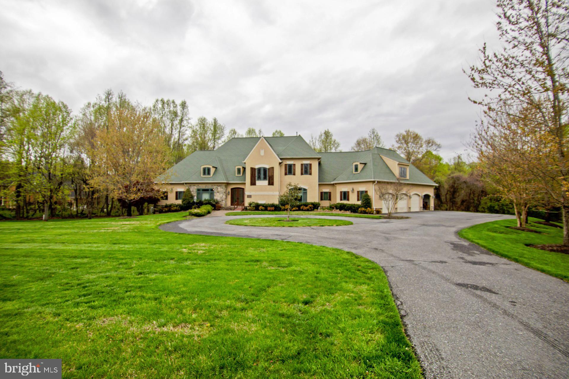 Price reduced! Appointment and proof of funds required. This exceptional custom-built estate in the Woods of Woodmore offers an exquisite blend of elegance, comfort, and craftsmanship. This remarkable residence has exceptional curb appeal matching the home’s attractive exterior, featuring distinctive architecture. The circular driveway, partial stone facade and oversized four-car garage add a level of elegance fitting for a community of exceptional homes. With a total of 5 bedrooms, 3.5 bathrooms, and 6,939 square feet of impeccably designed finished living space, every detail has been carefully curated. Step through the custom-designed front door, and a breathtaking two-story foyer with a circular staircase welcomes you. The main level offers a large study, a luxurious primary suite featuring an elegant tray ceiling, and an exceptionally large walk-in closet. The ensuite spa bath boasts custom tile work, premium finishes, a seated shower and Jacuzzi soaking tub. A gourmet chef’s kitchen serves as the heart of the home, featuring a granite island, top-of-the-line Subzero-Wolf range, custom cabinetry, and a stylish butler’s pantry. The adjacent family room, anchored by a gas fireplace and a wall of windows, creates a warm and inviting atmosphere. A morning room, formal dining room, expansive living room and a well-designed mudroom leads to the extra-large four-car garage with abundant storage and functionality. The upper level contains 4 bedrooms and an expansive family room with a fireplace and wet bar. The upper-level bedroom suite exudes elegance, complete with its soaring tray ceilings. The ensuite bathroom features a luxurious shower and Jacuzzi soaking tub. Two additional bedrooms share a distinctive bathroom. Another large bedroom suite with a massive study offers a half bath. With 4397 square feet of unfinished space, the lower level offers a blank canvas to create the space you truly want (e.g., gym, home theatre, game room, additional bedrooms, storage and an opportunity to increase home value through future finishing). Dual French doors naturally access the expansive backyard. Mature trees and lush greenery frame the flagstone patio. This amazing home is perfectly located in one of the most exquisite neighborhoods in Prince George’s County.