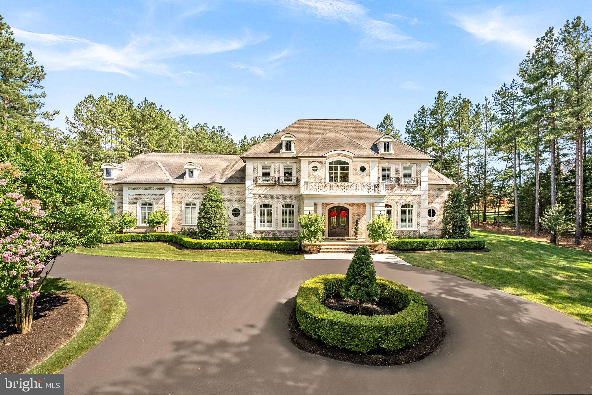 Welcome to a timeless masterpiece at 22608 Creighton Farms Drive—an exquisite French Manor estate, crafted with precision by Apex Custom Homes. This distinguished residence, nestled on a corner lot spanning over 3 acres, presents an opulent lifestyle with almost 10,000 square feet of luxurious living space.

As you arrive, a circular driveway flanked by monuments and large coach lights welcomes you. The grand entrance is adorned with front iron gate doors, leading to a two-story foyer with 25-foot ceilings and a floating solid wood staircase with iron spindles. The interior showcases chiseled travertine edge flooring, 8-inch reclaimed hardwoods, and detailed moldings throughout.

This estate features five bedrooms, each with en-suite marble or travertine bathrooms, and a primary suite on the main level boasting 16 foot ceilings,  dual chandeliers, and floor-to-ceiling marble surround fireplace with a 7-foot mantle.  The opulent primary bathroom features Calcutta marble floors, two water closets, a double sink vanity with a separate make-up area, soaking air jet bubble tub, spacious dual seamless glass walk-in shower, and a stunning John Richards chandelier.

The gourmet kitchen is a chef's dream, equipped with Wolf and Sub-Zero appliances, a 9.5-foot island with new quartz countertops/backsplash, and reverse osmosis water system.  

Indulge in leisure with a private home theater, wine cellar, and recreation room. The outdoor oasis includes an Pristine Acres heated, saltwater pool with spa, fire bowls, and an outdoor kitchen under a custom pavilion.   The newly added outdoor bathroom/pool changing house is a designers dream.  9 foot resort style fire table as well as a separate stand alone fireplace offer everything any entertainer would want in their backyard.  Security and convenience are ensured with a whole-house generator, alarm system, and gated community.   This estate is a sanctuary of elegance and comfort, awaiting its next discerning owner.