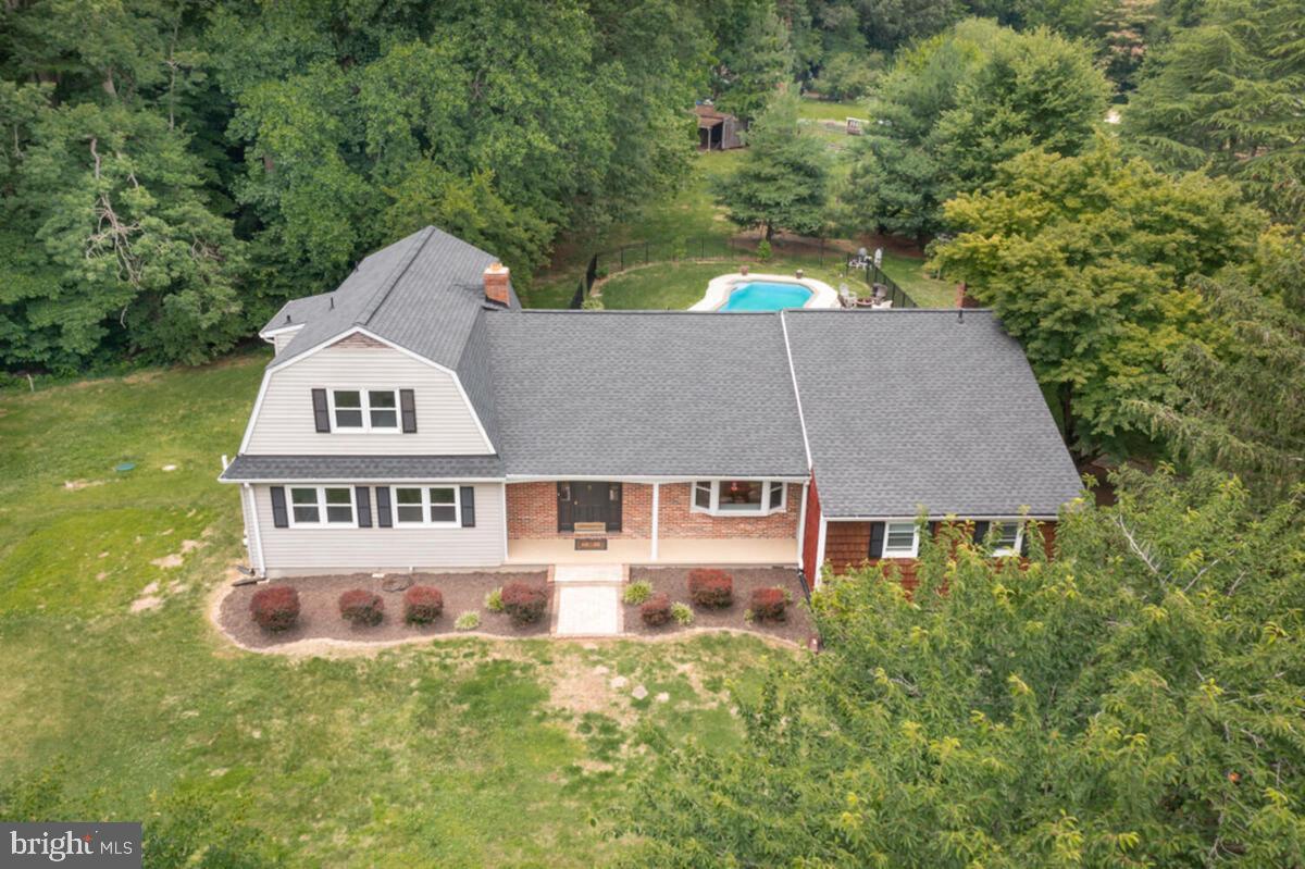 Enjoy the tranquil setting of this 3.32-acre farmette featuring 2 pastures, a paddock, and a private fenced rear yard with a deck leading down to an in-ground gunite swimming pool overlooking the expansive property.  This spacious rambler with a two-story addition offers over 5,000 square feet of living space with 5 bedrooms and 3.5 bathrooms. The main level features a primary suite, an updated kitchen with an island and stainless steel appliances, two additional bedrooms, a living room with a brick fireplace, a formal dining room, a step-down family room, and a laundry room.  The upper level includes two bedrooms and a full bathroom.  In contrast, the lower level offers a large recreation room with another brick fireplace, recessed lighting, and an expansive storage area with potential for additional finished living space.  Additional highlights include an attached side-load 2-car garage and a peaceful country setting ideal for entertaining, recreation, or hobby farm living.