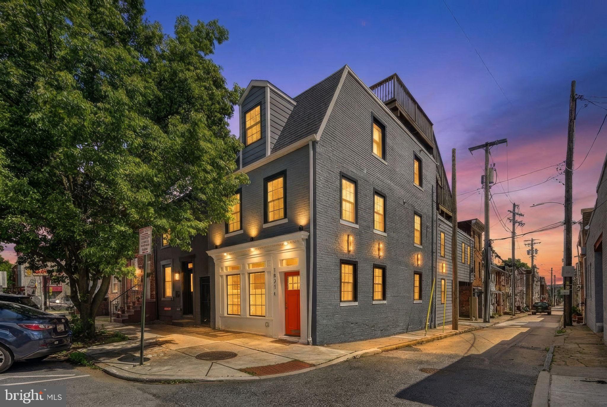 Welcome to 1821 Bank Street, a beautifully updated corner home in one of Baltimore’s most desirable city locations. This striking residence blends historic charm with modern style, featuring a bright open layout, wide-plank wood floors, a dramatic coffered ceiling, and a custom stone accent wall that anchors the main living space.

Designed for both everyday living and entertaining, the home offers seamless flow between the living, dining, and kitchen areas with tasteful updates and elevated finishes throughout. The exterior is equally impressive, with strong curb appeal, a carport, and a rare multi-tiered roof deck that provides exceptional space for relaxing, hosting, and enjoying panoramic city views.

Ideally located near dining, shopping, waterfront attractions, and all the best of Baltimore city living, this home offers a unique combination of character, convenience, and standout outdoor amenities.