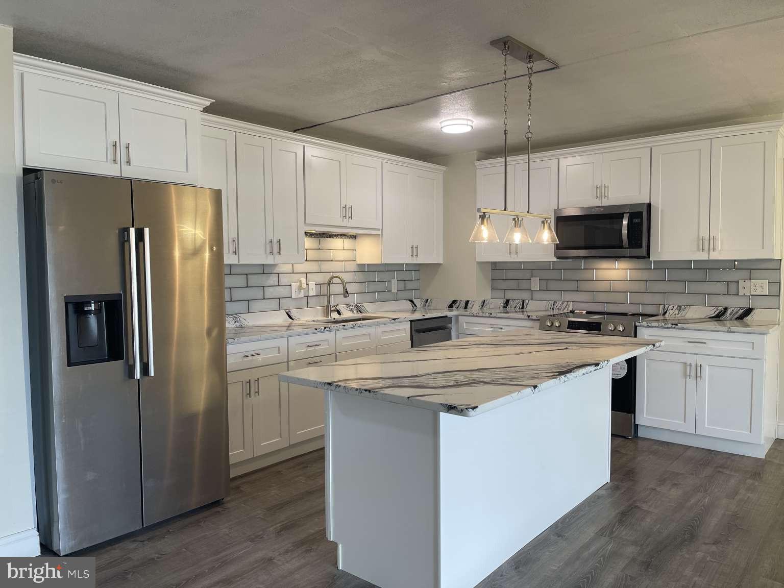 Welcome to this beautifully renovated 2-bedroom condo at 84 Welsh Tract Rd, Newark, DE, 19713, Apt #306; offering modern upgrades, an open layout, and a clean move-in ready feel. Step inside to brand-new flooring, fresh neutral paint, updated lighting, and a spacious living area that flows directly to a private patio. The fully updated kitchen is the centerpiece of the home, featuring white shaker cabinets, stainless steel appliances, marble-style countertops, a large center island, subway tile backsplash, and modern pendant lighting. The open-concept design makes the space perfect for relaxing, entertaining, or enjoying everyday living. The bathroom has been tastefully upgraded with a glass shower enclosure, modern tile, updated vanity, black fixtures, and contemporary lighting. Both bedrooms offer comfortable living space, natural light, modern flooring, and generous closet storage. With stylish finishes throughout, a private patio, updated kitchen and bath, and a bright open floor plan, this condo is ready for its next owner.