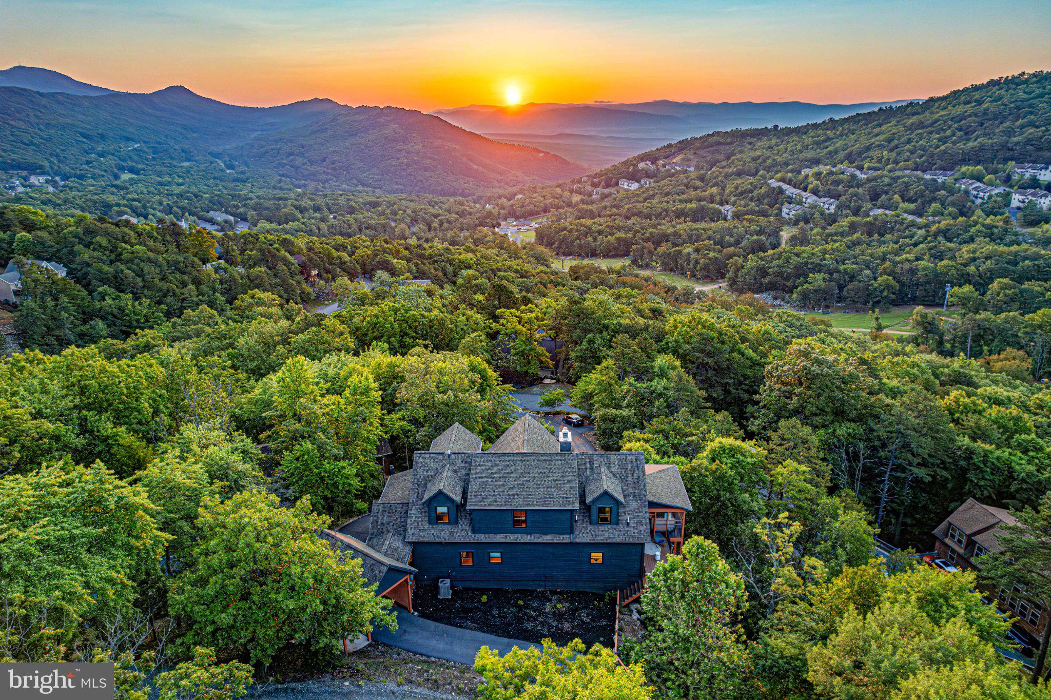 Commanding one of the most breathtaking views in Massanutten Resort, 780 Rainier Road stands in a class of its own. Positioned atop the mountain with panoramic views stretching across the Shenandoah Valley, Blue Ridge Mountains, and ski slopes below, this extraordinary HGTV-designed retreat represents the pinnacle of luxury resort living.

Offering over 4,500 square feet of thoughtfully designed living space, the home was built around the view. Walls of glass capture unforgettable sunrises and mountain vistas from nearly every room, including the primary suite and spa-inspired bath. Whether relaxing in the hot tub, enjoying the barrel sauna, gathering around the outdoor fireplace, or watching skiers carve down the slopes, the scenery remains the centerpiece of every experience.

Designed to entertain on a grand scale, the home features 5 bedrooms, 5.5 bathrooms, a private theater room, expansive game room with billiards, ping pong, shuffleboard and arcade games, multiple indoor and outdoor gathering spaces, and accommodations for up to 14 guests. The chef's kitchen, soaring great room, and expansive decks create the ideal setting for family retreats, corporate gatherings, or luxury vacation experiences.

Included in the sale is the adjacent buildable parcel, providing a rare combination of additional privacy, protected views, and future flexibility. Opportunities to acquire neighboring land at this elevation are exceptionally rare and further distinguish this property from every other offering within the resort.

For those familiar with Massanutten, properties of this caliber seldom become available. Combining unmatched views, luxury amenities, privacy, and proven short-term rental appeal, 780 Rainier Road represents a true legacy property within Virginia's premier four-season resort destination.

Simply put, there is nothing else like it.