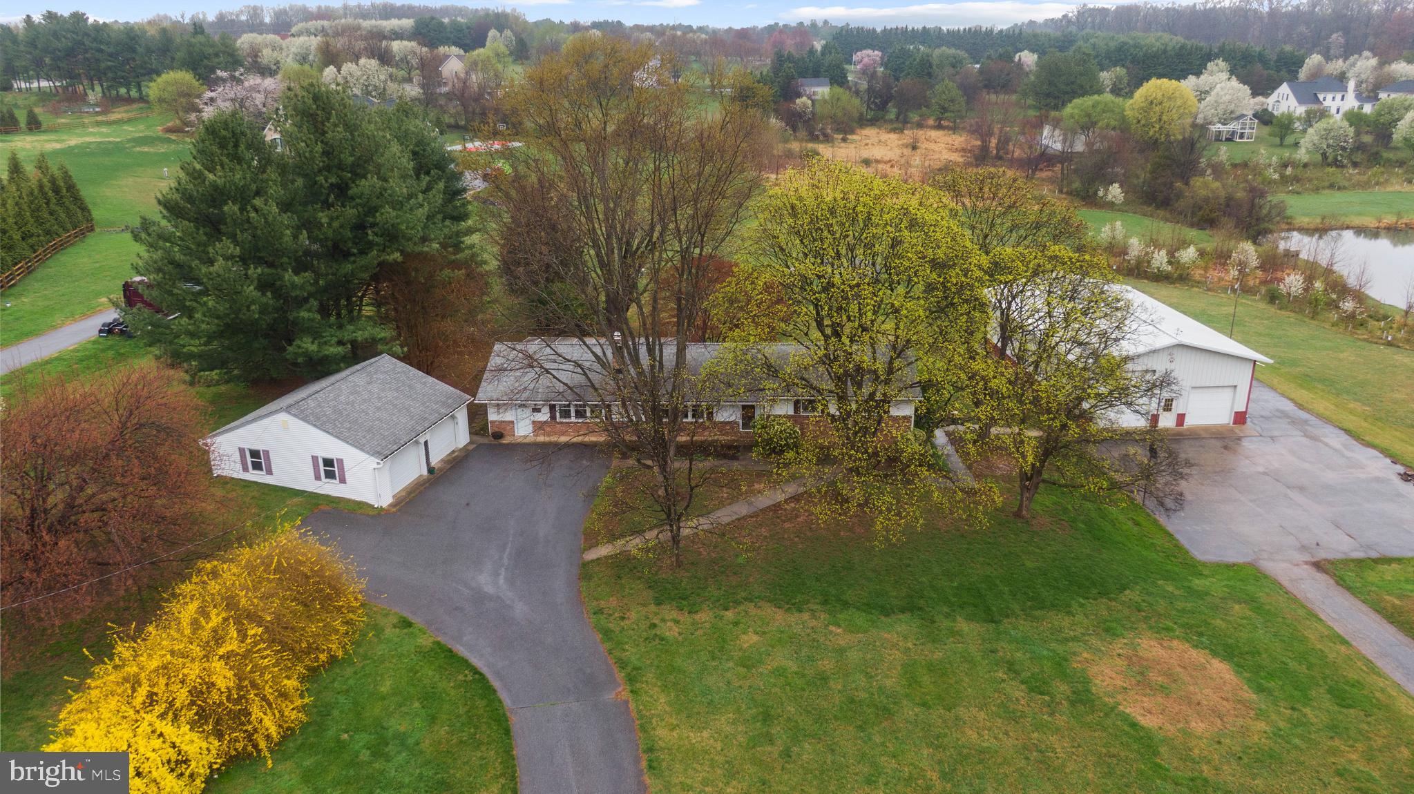 Wow! This well-maintained, five-bedroom rancher with TWO detached garages sits on more than one and a half acres in idyllic Clarksville and is ready for its new owner! With two finished levels and more than 3,000 square feet, this home offers an abundance of flexible space to suit your needs. The main level showcases the home’s primary living area, including the living room, kitchen, and dining room as well as three bedrooms, a large family/recreation room, and a sunroom. The living room has a wood burning fireplace. The kitchen, with oak cabinets and Corian counters, is a cook’s delight with an abundance of prep and storage space as well as an adjacent dining room. The kitchen also offers access to the fabulously large family/recreation room with its own private entrance as well as access to the sunroom and deck. The sunroom offers views of the back yard as well as a neighboring pond. Three bedrooms and two full baths complete the main level. One of the bedrooms is currently set up as a laundry room/office but can be easily reverted to bedroom space. The primary bedroom has its own en-suite bathroom. Downstairs, there is an in-law suite/ADU that can be accessed from within the house as well as from its private, covered entrance at the home’s rear. This area boasts two additional bedrooms, a kitchen and living room, and a full bath. There is also a large storage closet and laundry/utility room on this level that services both levels of the home. In addition to a detached two-car garage, the property also has a second garage, which is an approximately 30’ x 60’ Morton Building with two garage bays. One door is oversized, ideal for a recreational vehicle. Inside, the building has heat, water, a separate electric panel, a compressed air system, 50-amp outlets, a workshop area, and stairway access to additional storage. This garage is served by its own driveway and parking area. Howard County Schools. No HOA. The house is conveniently located just minutes from Rts. 108 and 32 and is being sold As-Is. The seller has set an offer deadline for 9:00 p.m., Tuesday, April 15 but reserves the right to accept an offer prior to the deadline.