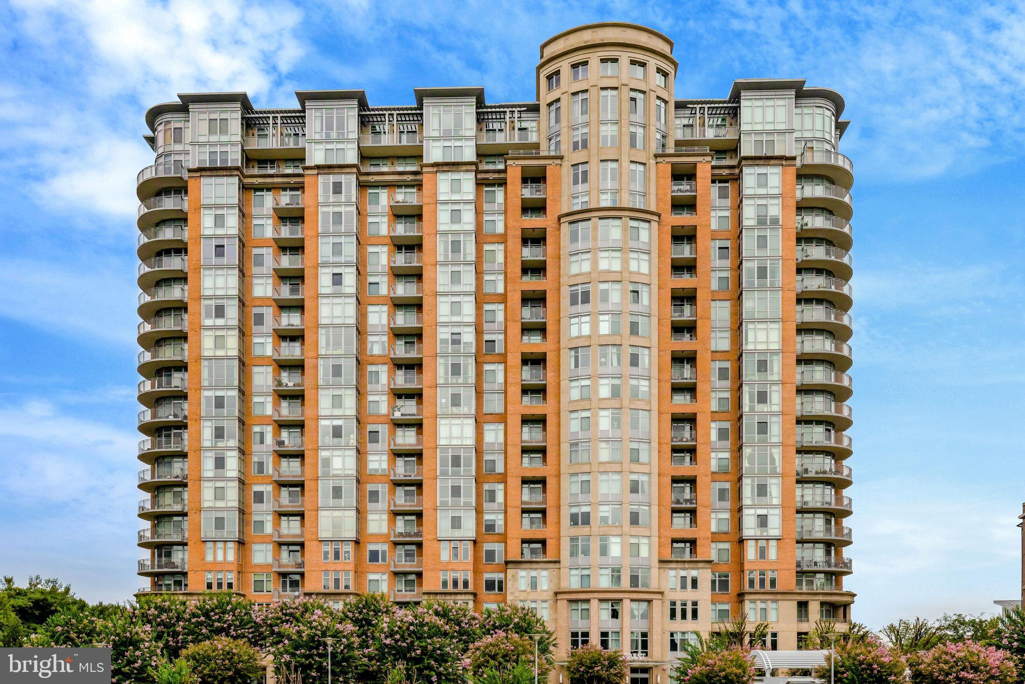 Stunning 2BR/2.5BA PLUS DEN CORNER UNIT with 1,621 sqft in the heart of Tysons! Freshly painted throughout with brand-new carpet and new ceiling light fixtures in bedrooms and new Luxury Vinyl flooring in the main areas, this light-filled residence offers an open-concept layout ideal for both everyday living and entertaining. The gourmet kitchen features stainless steel appliances with new dishwasher, a large center island, and overlooks the spacious living and dining areas. There is an expansive corner balcony for extended outdoor living space bringing in lots of natural light. Both generously sized bedrooms include walk-in closets and en-suite baths.  Built-in wall safe in the walk-in closet in the back bedroom. Lovely renovated half bath for guests. Two garage parking spaces convey (#079 & 087). Enjoy luxury building amenities including concierge, fitness center, pool, party room, and more. Prime location just minutes to Tysons Corner, The Boro, Silver Line Metro, major commuter routes (I-495, Rt 123, Rt 7), shopping, dining, and entertainment.
