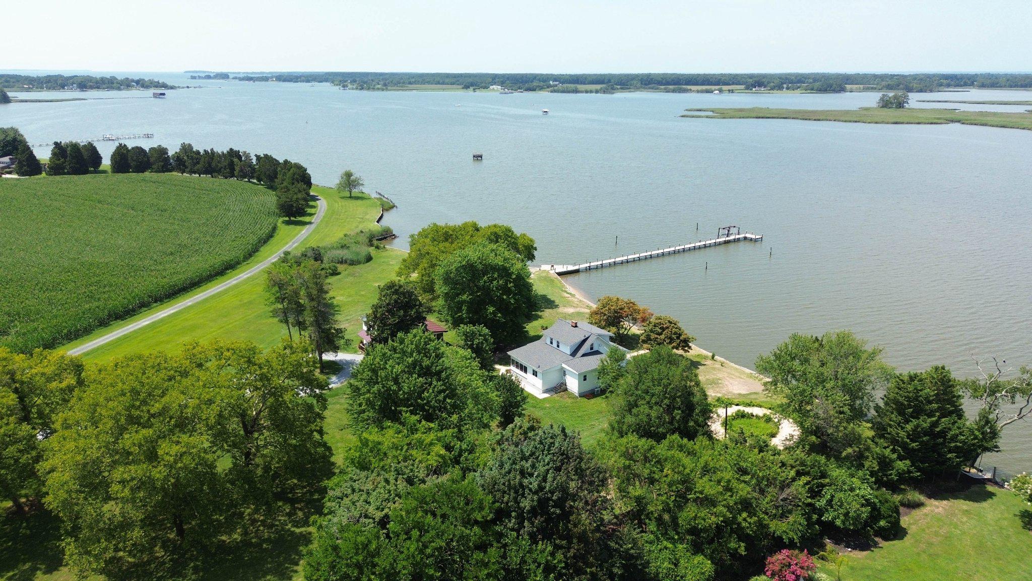 Privacy without isolation.  This property will change your mind it you think you need 10 or 20 acres to have wide open spaces and not have neighbors breathing down your neck! Two separate living quarters, each with unobstructed views and up to date amenities. Discover a captivating blend of traditional charm and  vintage cape cod  in the primary 3-bedroom, 2-bathroom residence, recently  updated in spring 2026   enhancing its already impressive appeal. Nestled in a serene rural setting, this home boasts  picturesque views along the banks of Cox Creek, offering panoramic western vistas that will take your breath away, especially as the sun sets on the horizon.  Step inside to find a thoughtfully designed interior featuring rich wood floors and upgraded countertops that elevate the kitchen, a home  perfect for gatherings. The cozy living room, complete with a brick fireplace and mantel, invites warmth and relaxation. Enjoy the convenience of an entry-level bedroom and a traditional floor plan that flows seamlessly throughout. The exterior is equally impressive, featuring a private beach and a circular gravel driveway that accommodates ample parking. With 548 feet of waterfrontage, indulge in fishing, boating, or simply soaking in the tranquil surroundings. The property includes a private dock with electric hoist and ramp, making water access effortless. Additional highlights include a guest house(2BR, 1.5 BA, KT,screened porch) and a storage building providing versatility for equipment or hobbies. The secluded parcel offers year-round access, ensuring your retreat is always within reach. This home is not just a residence; it's a lifestyle waiting to be embraced. Don't miss the opportunity to make this serene haven your own!  Less than 30 minutes to Annapolis, 50 minutes to Baltimore or DC.  Convenient to area restaurants and points of interest. Not in a subdivision.  Perfect for multi-generational living, private guest quarters,  or possible rental income. Room for expansion of living spaces, outdoor sports court, horseshoes, bocci, or garden.  Former  waterside pool  could be revitalized, subject to county approval.
