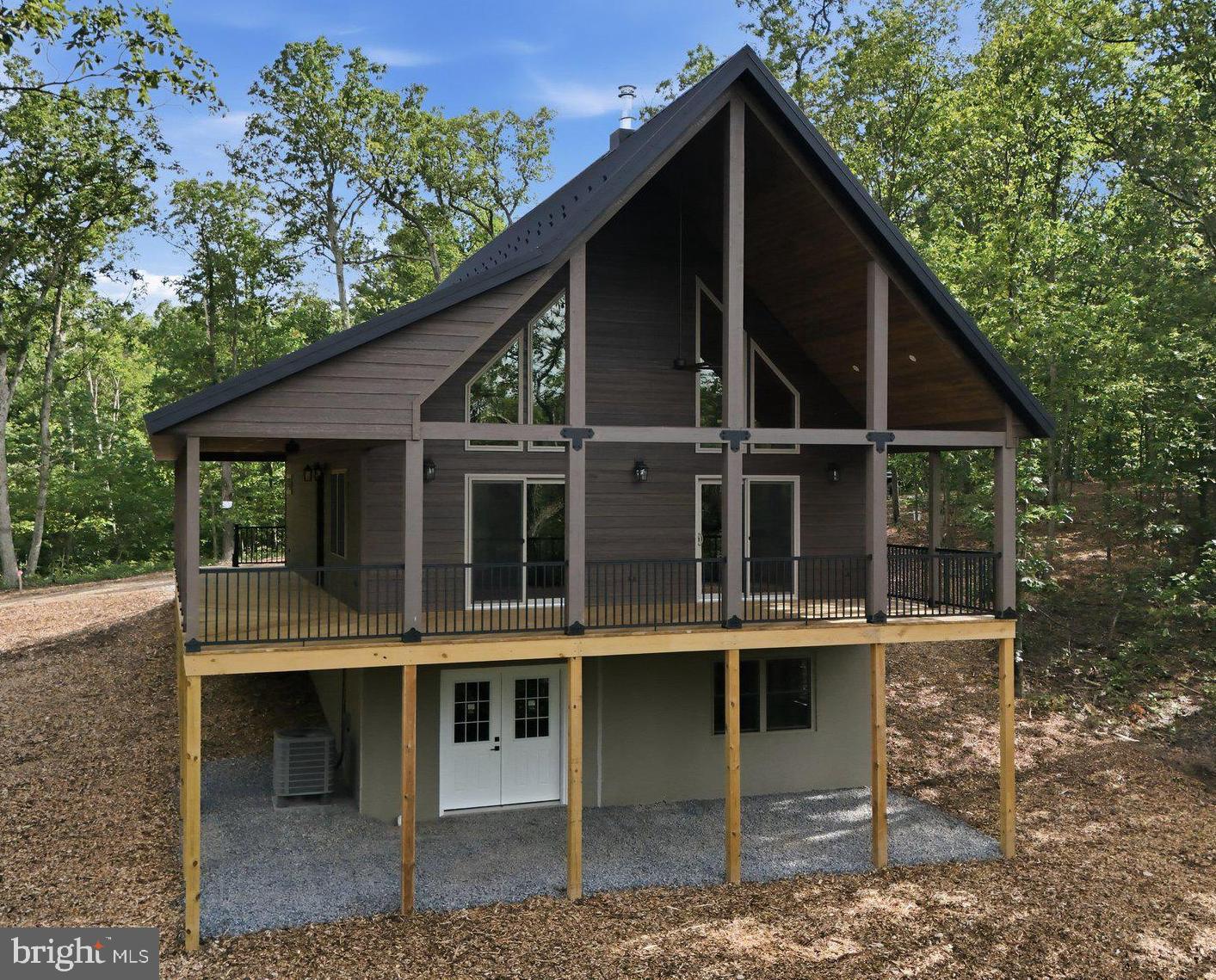 NEW  MOUNTAIN  CHALET! Built to very high standards and waiting for your approval, there will be no disappointments here! Enter the door into the Great Room and be greeted with high cathedral pine ceilings, stunning fixtures, beautiful stone work that centers the wood burning stove within the breathtaking window wall. The kitchen area has granite counters, custom hickory cabinetry that was built by local craftsmen.  The main floor bedroom is spacious and takes advantage of the perfectly designed luxury bath with jetted soaking tub, double walk-in shower, granite vanity tops. With the laundry on the main floor this home is built for conveinance. The upper level takes in the grand feel of the open space but offers a private large bedroom with a fully appointed private bath and your own personal balcony. The covered decks will offer years of enjoyment, with the front deck taking in the mountain view and offering protection from the rain and snow, giving a Lodge look and feel. This is an option that is extremely rare within our area.  The foundation of this home is a full walkout design, constructed with the Superior Wall System, and is already pumbed for a third bath and layed out for an additional bedroom and family game / rec room, for you to consider completing later. Add all this to a great location, within 15 minutes of Berkeley Springs and not far from I-70 and the Potomac River, making this one property you cant afford to miss, so make that appointment today!!