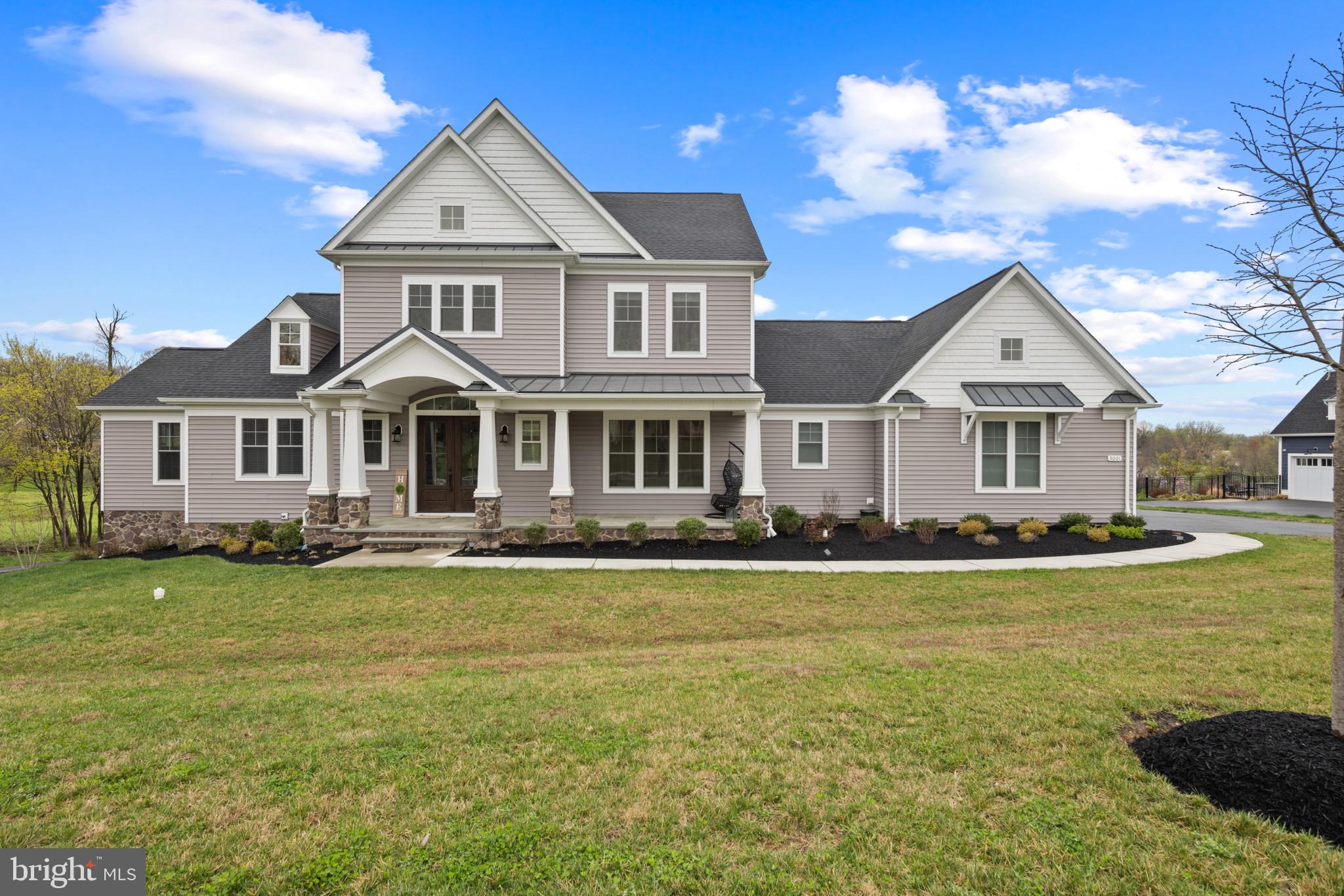 Built in 2021 by Catonsville Homes and meticulously maintained by the original owners, this stunning farmhouse offers a rare blend of refined living and serene countryside charm. Set on nearly an acre of open green space with sweeping countryside views, the home captivates from the start with its charming stone and vinyl exterior, lush landscaping, and inviting front porch.

Step inside to discover an immaculate interior defined by expert craftsmanship, luxurious finishes, and thoughtfully designed living spaces. Rich hardwood floors flow from the welcoming foyer into the formal living room, setting the tone for the elegance found throughout. At the heart of the home is an inviting family room featuring a cozy gas fireplace framed by floor-to-ceiling stonework and accented by striking exposed wood beams. The seamless open layout connects this space to the gourmet eat-in kitchen, beautifully appointed with quartzite countertops, crisp white cabinetry, a sleek subway tile backsplash with a patterned tile accent, stainless steel appliances, an oversized island with seating, a walk-in pantry, and a sunlit breakfast area with direct access to the porch. The main-level primary suite provides a peaceful retreat with hardwood floors, a tray ceiling, a spacious walk-in closet, and a spa-like en suite bath with a Roman tub. An additional bedroom suite on this level offers flexibility for guests or multigenerational living. For added convenience, the main level also includes a well-equipped mudroom, a large laundry room, and a stylish powder room.

Upstairs, a spacious loft offers a flexible area ideal for reading and three generously sized bedrooms, each featuring large closets and private en suite bathrooms. The fully finished lower level adds even more living space with luxury vinyl tile flooring throughout the expansive recreation room showcasing a cleverly designed layout accommodating a lounge, game area, and media center complete with a full bathroom and walk-out access to the backyard. Additional storage and utility rooms add functionality. Outdoor living is equally exceptional, with a screened porch and a deck perfect for al fresco dining or simply enjoying the peace and beauty of the surrounding countryside.