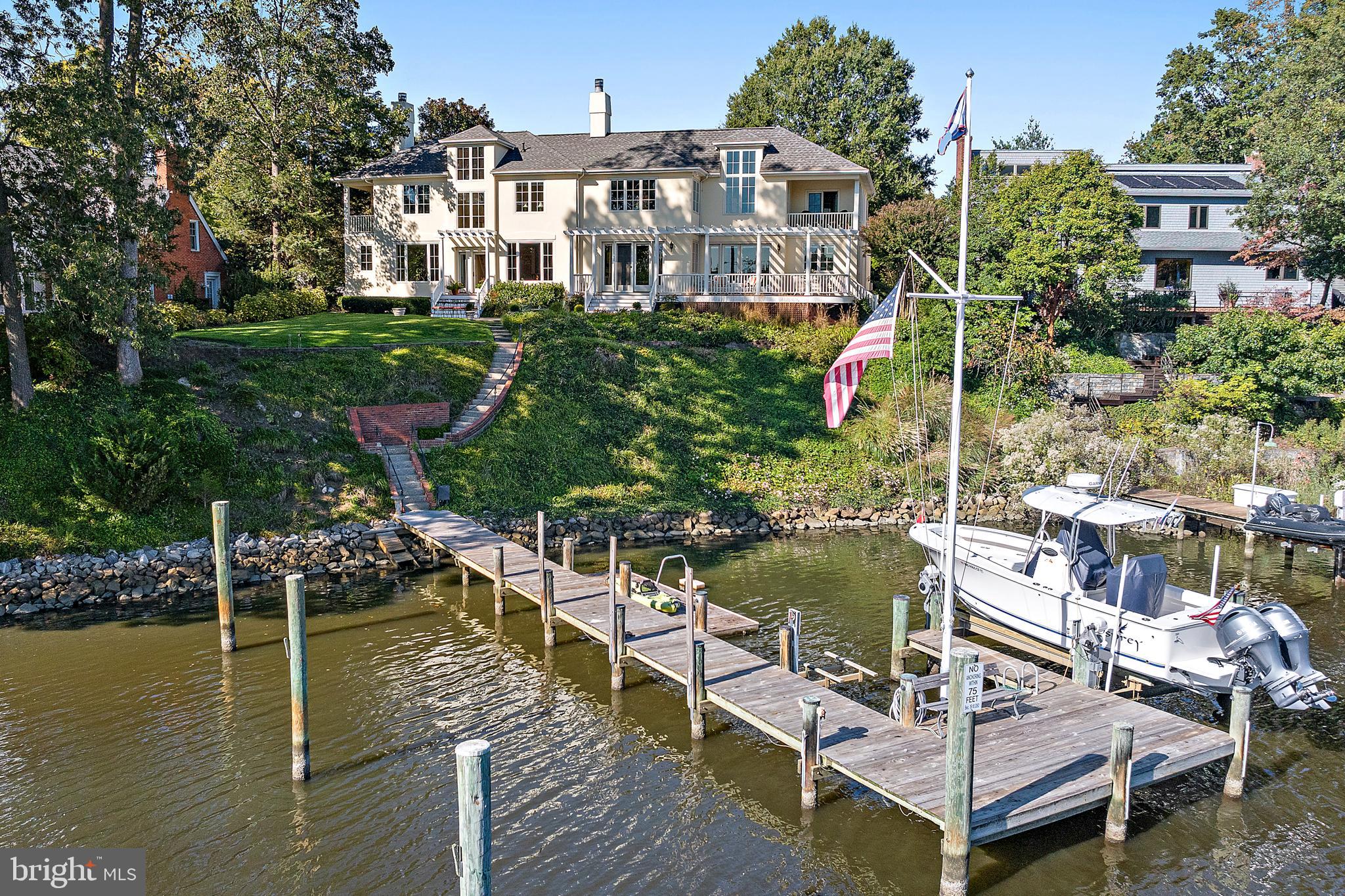 Custom built and beautifully sited on Spa Creek, this waterfront residence offers just over 5,000 square feet of above-ground living space with 6 ft MLW, private pier with 10,000 lb boat lift, floating dock  and sweeping water views of Spa Creek. A gracious front hallway entrance with a curved staircase sets the tone for the home’s elegant design and inviting flow. The main level features hardwood floors, recessed lighting, and water views from nearly every room. The living room includes built-in bookcases and a wood-burning fireplace, while the family room—located off the kitchen—offers a second wood-burning fireplace and access to the expansive IPE deck with pergola. The dining room overlooks Spa Creek, and the custom kitchen features white cabinetry, refinished granite countertops, Thermador appliances, and a large island with gas cooktop.
Upstairs, the spacious primary suite includes cathedral ceilings, a gas fireplace, soaking tub, walk-in closet, and an adjoining office/flex space with private waterfront balcony. Additional highlights include a guest suite with balcony, third-floor studio/office, and separate in-law or nanny quarters with full bath, kitchenette, and private entrance. A large mudroom with multiple closets, laundry area, and half bath connects to the oversized two-car garage.
Recent upgrades include an architectural-grade roof (2023), resurfaced Dryvit exterior (2023), two new hot water heaters (2025), encapsulated crawl spaces (2025), new smoke detectors (2025), and a whole-house generator. Exceptional waterfront living just minutes from downtown Annapolis.